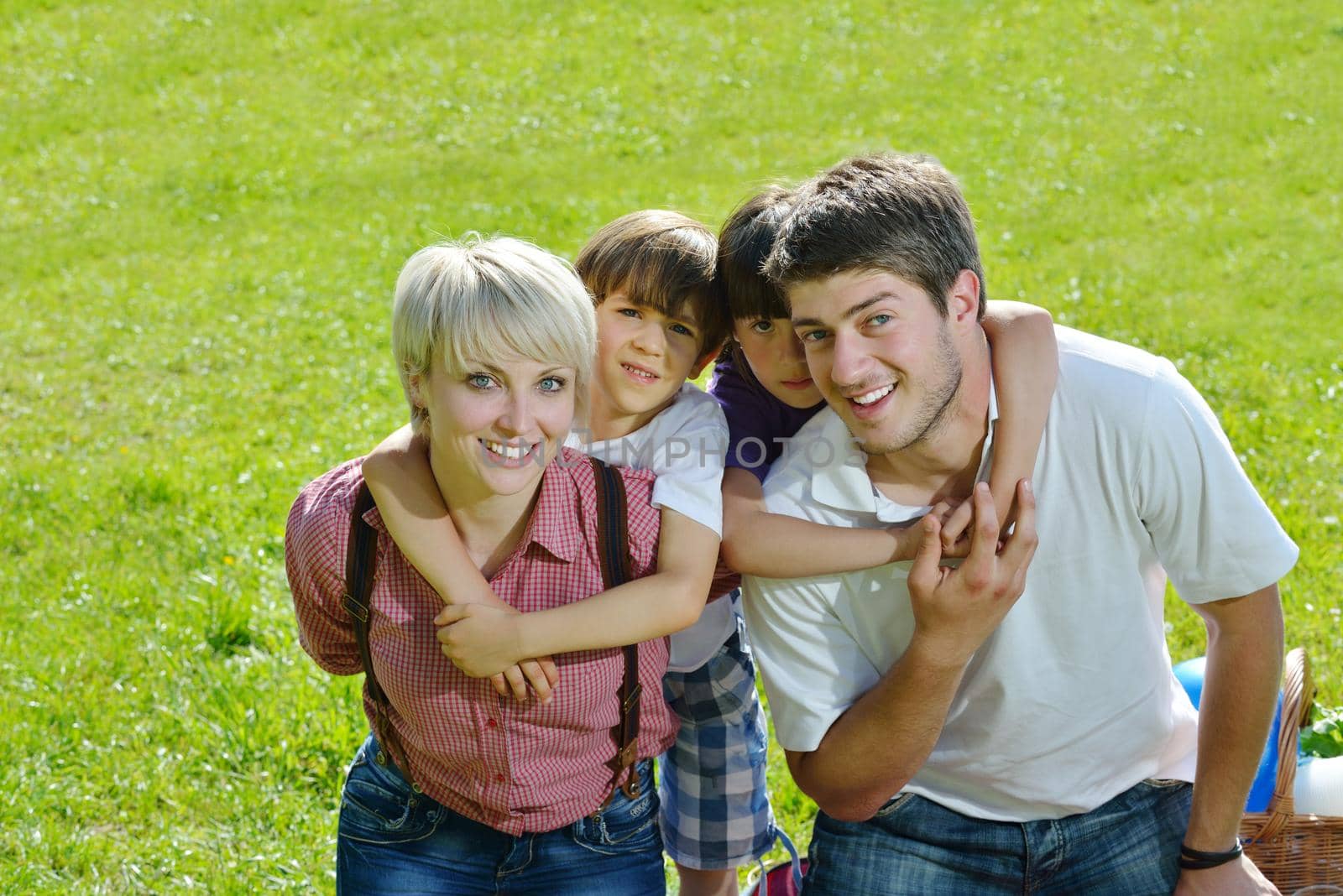 happy young family with their kids have fun and relax outdoors in nature with blue sky in background