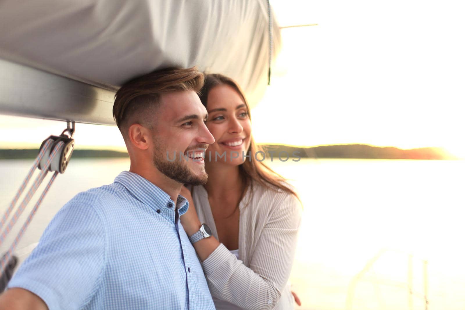 Attractive couple on a yacht enjoy bright sunny day on vacation.