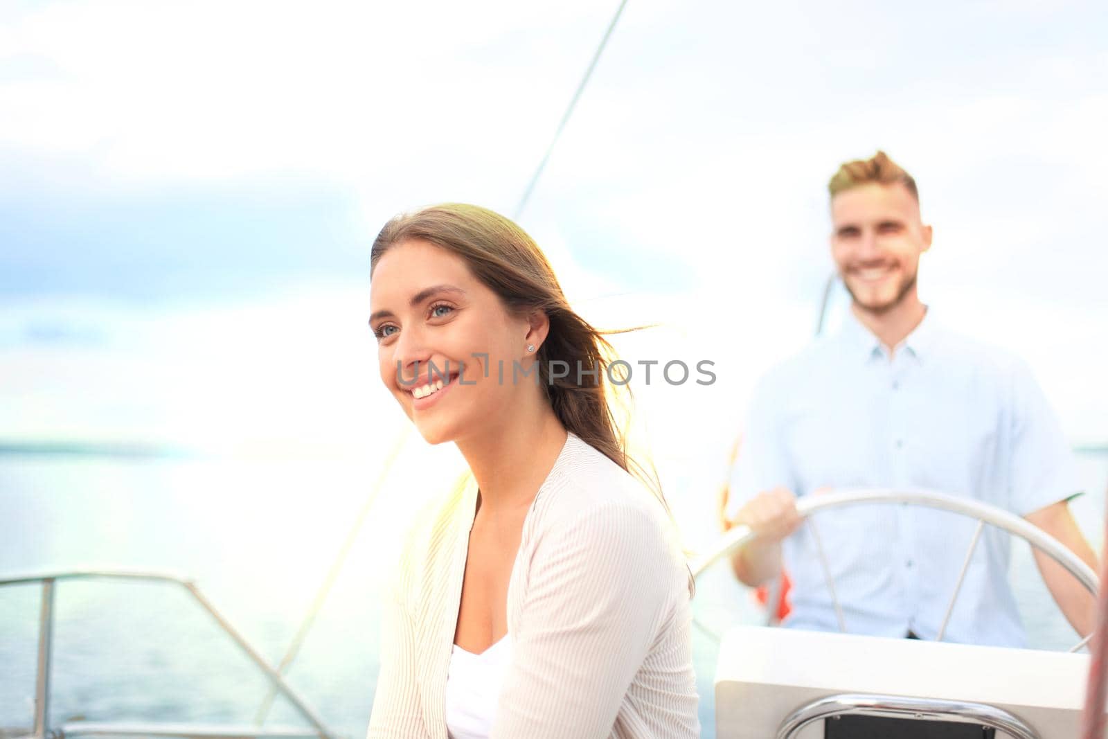 Attractive couple on a yacht enjoy bright sunny day on vacation. by tsyhun