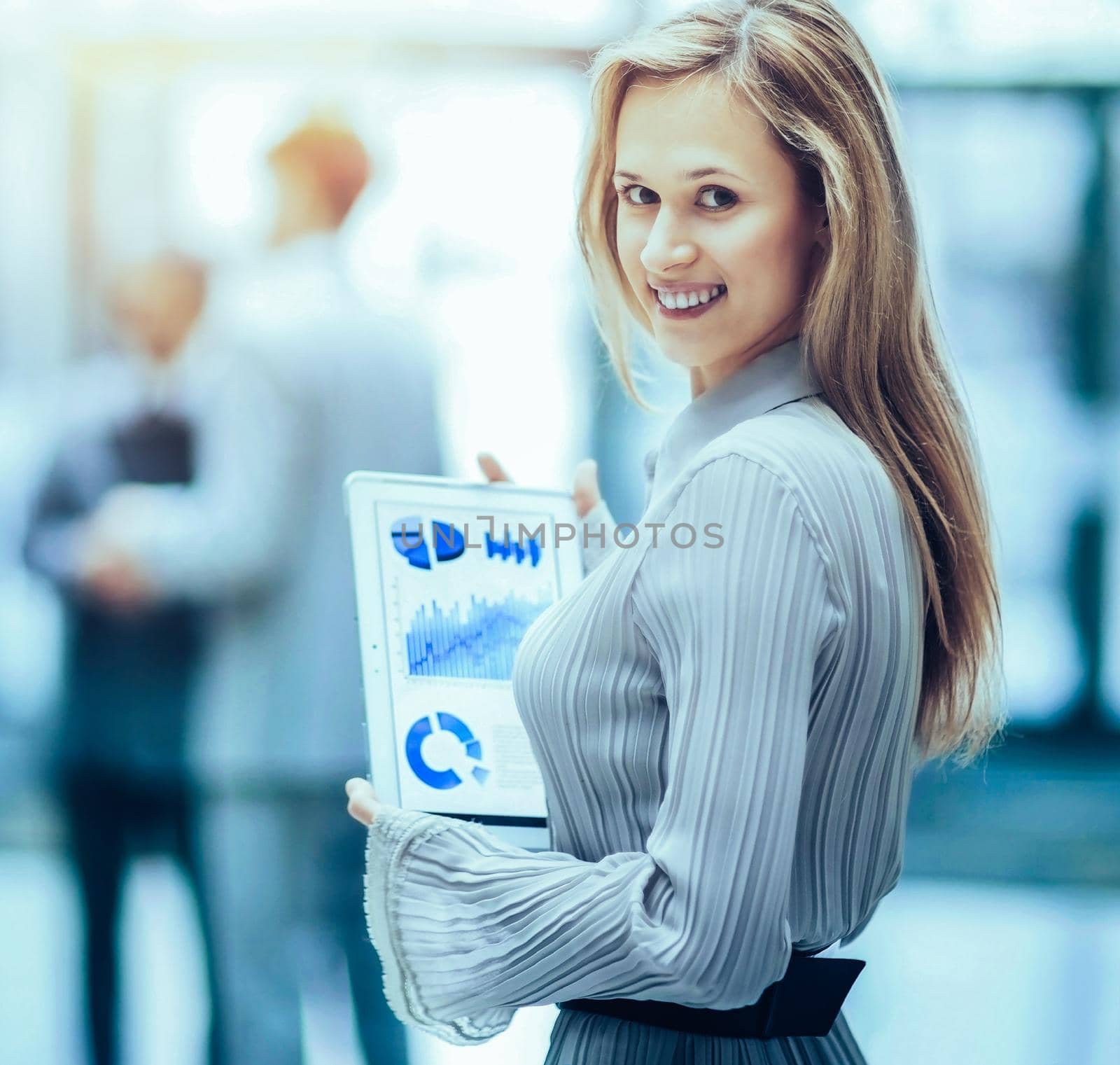 Successful business woman with charts in hand on the background of her business team