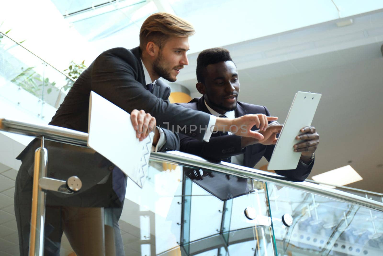 Bottom view. Two multinational young businessmen discussing at office during business meeting.