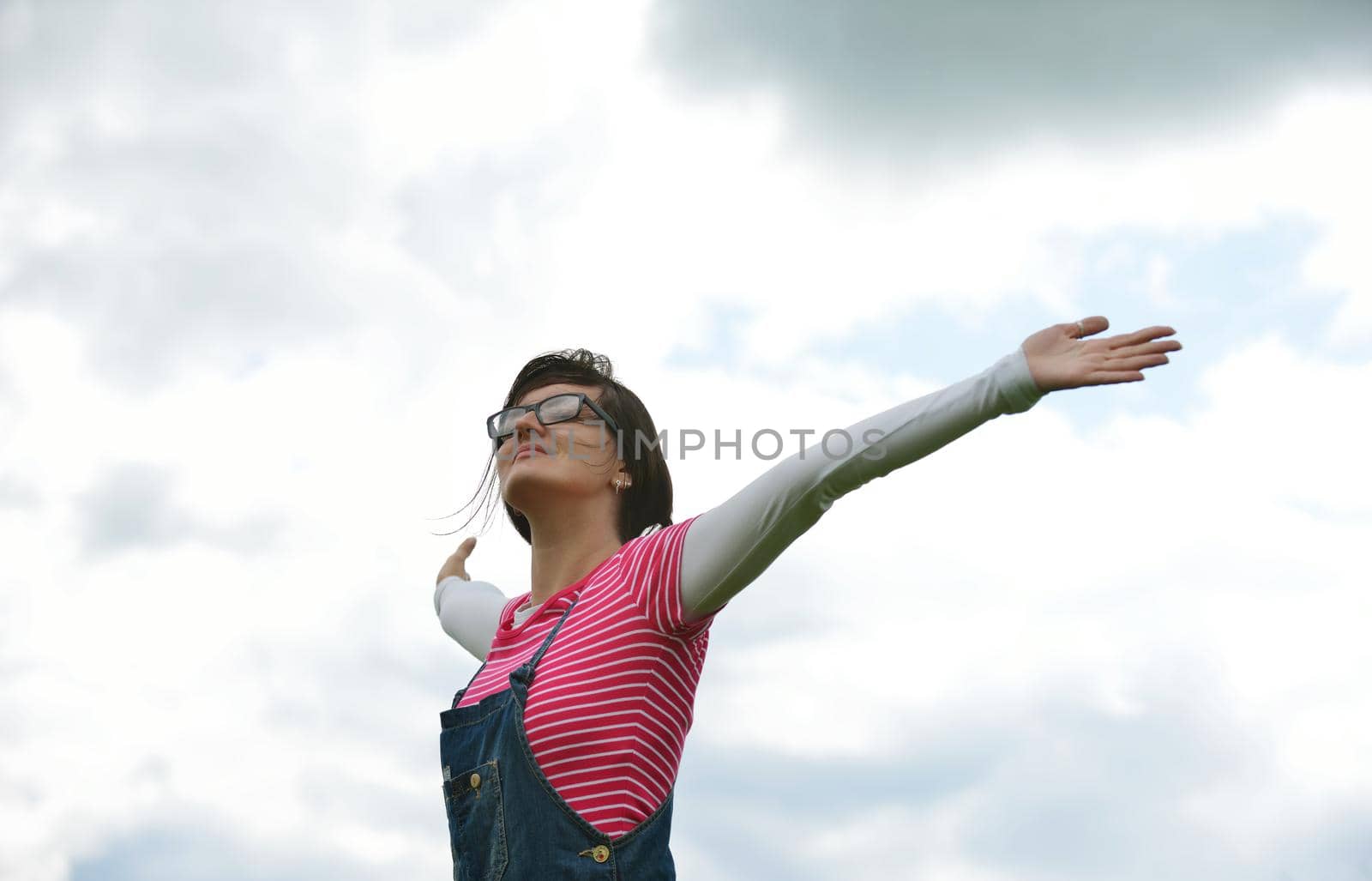 Enjoying the nature and life. Young woman arms raised enjoying the fresh air in green nature