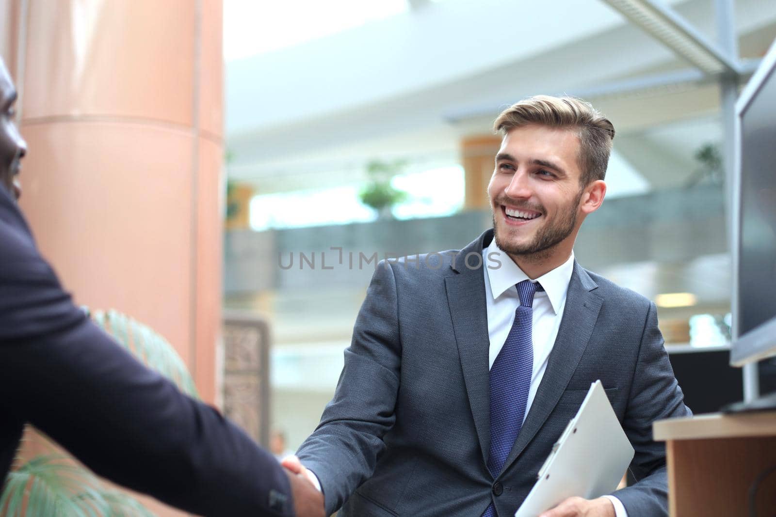 Business meeting. African American businessman shaking hands with caucasian businessman. by tsyhun