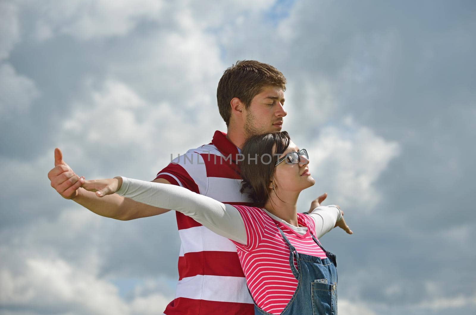 Portrait of romantic young couple in love  smiling together outdoor in nature with blue sky in background