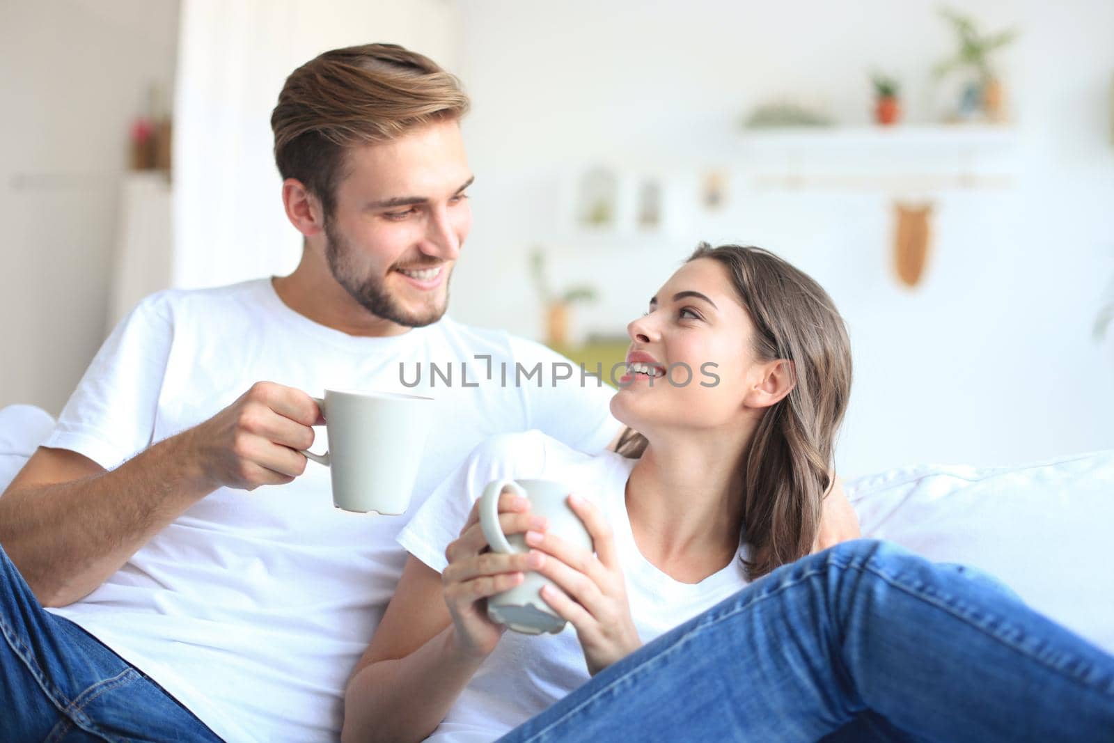Cheerful young couple in the morning at home in the living room.