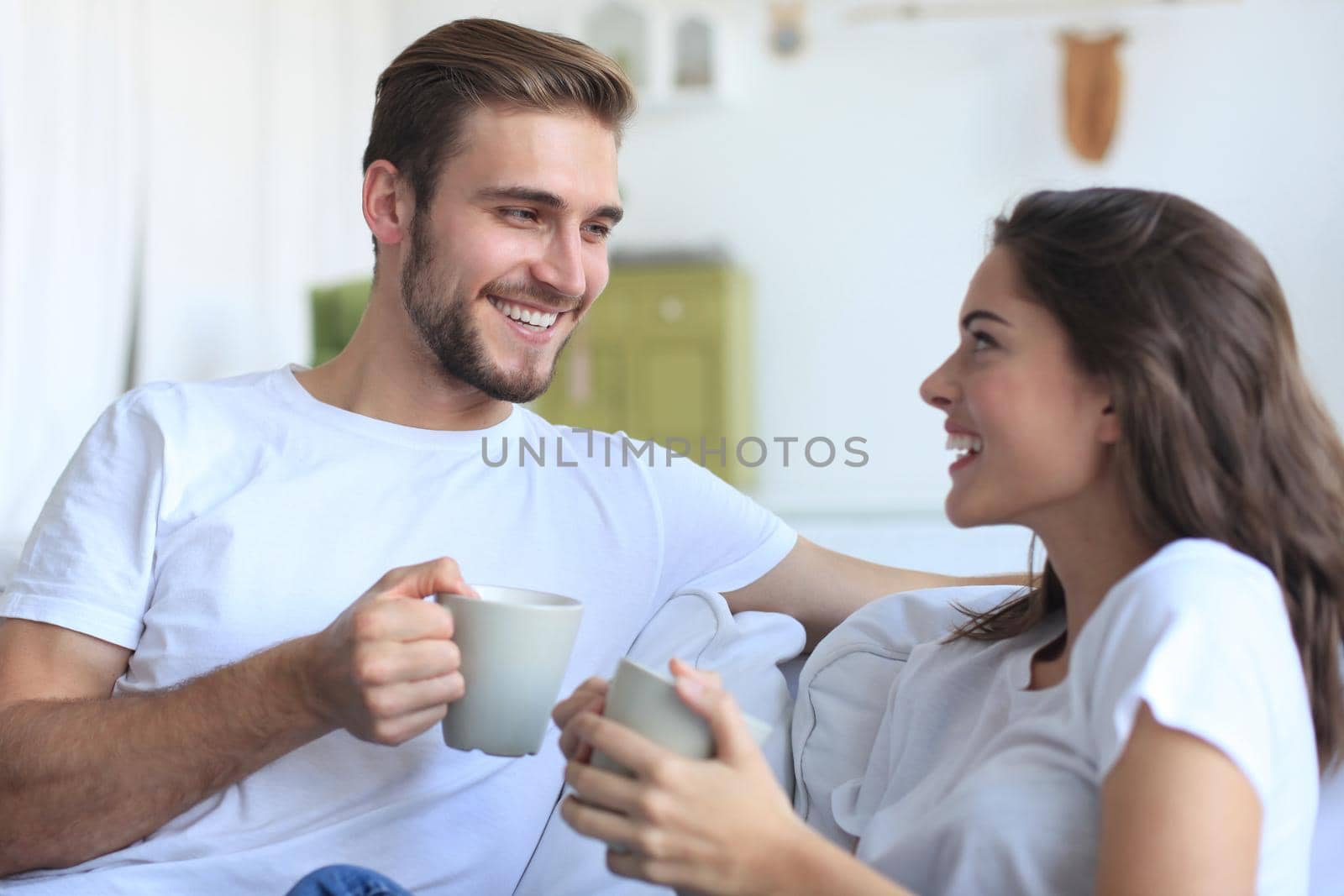 Cheerful young couple in the morning at home in the living room.