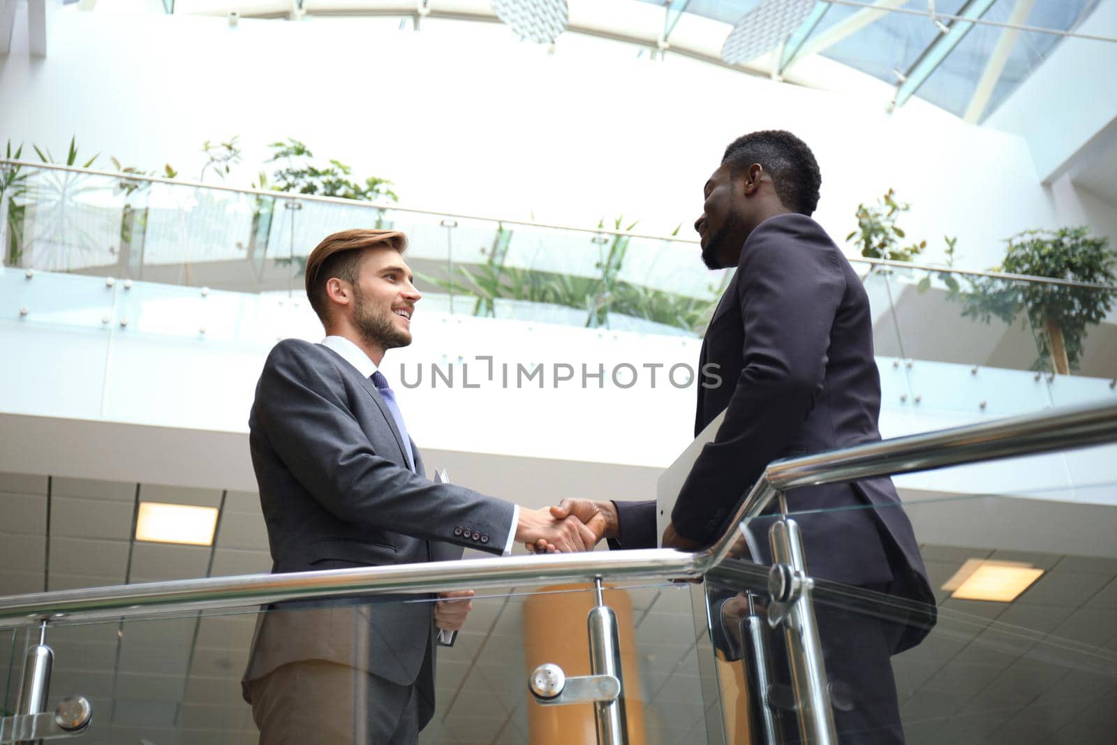 Bottom view. Business meeting. African American businessman shaking hands with caucasian businessman.