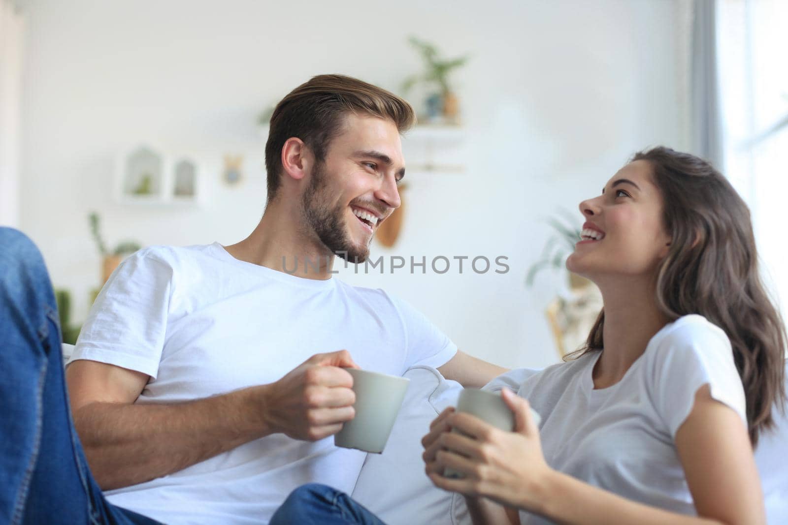 Cheerful young couple in the morning at home in the living room.