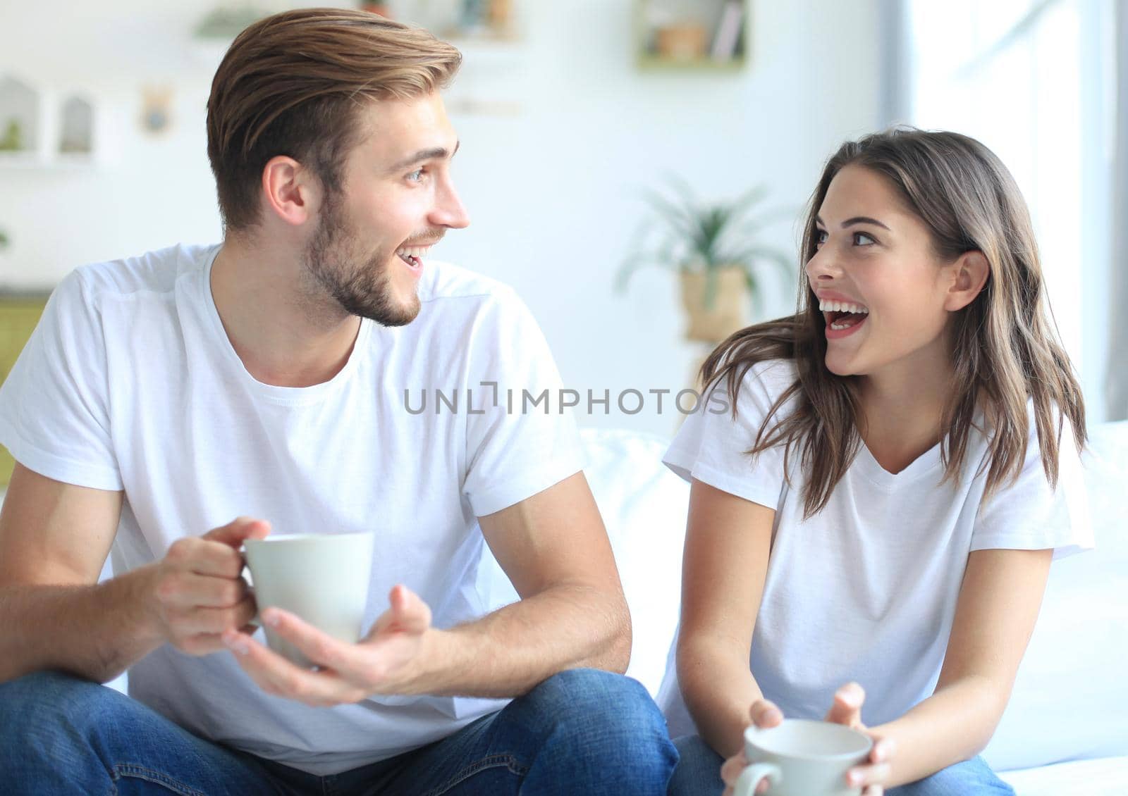 Cheerful young couple in the morning at home in the living room.