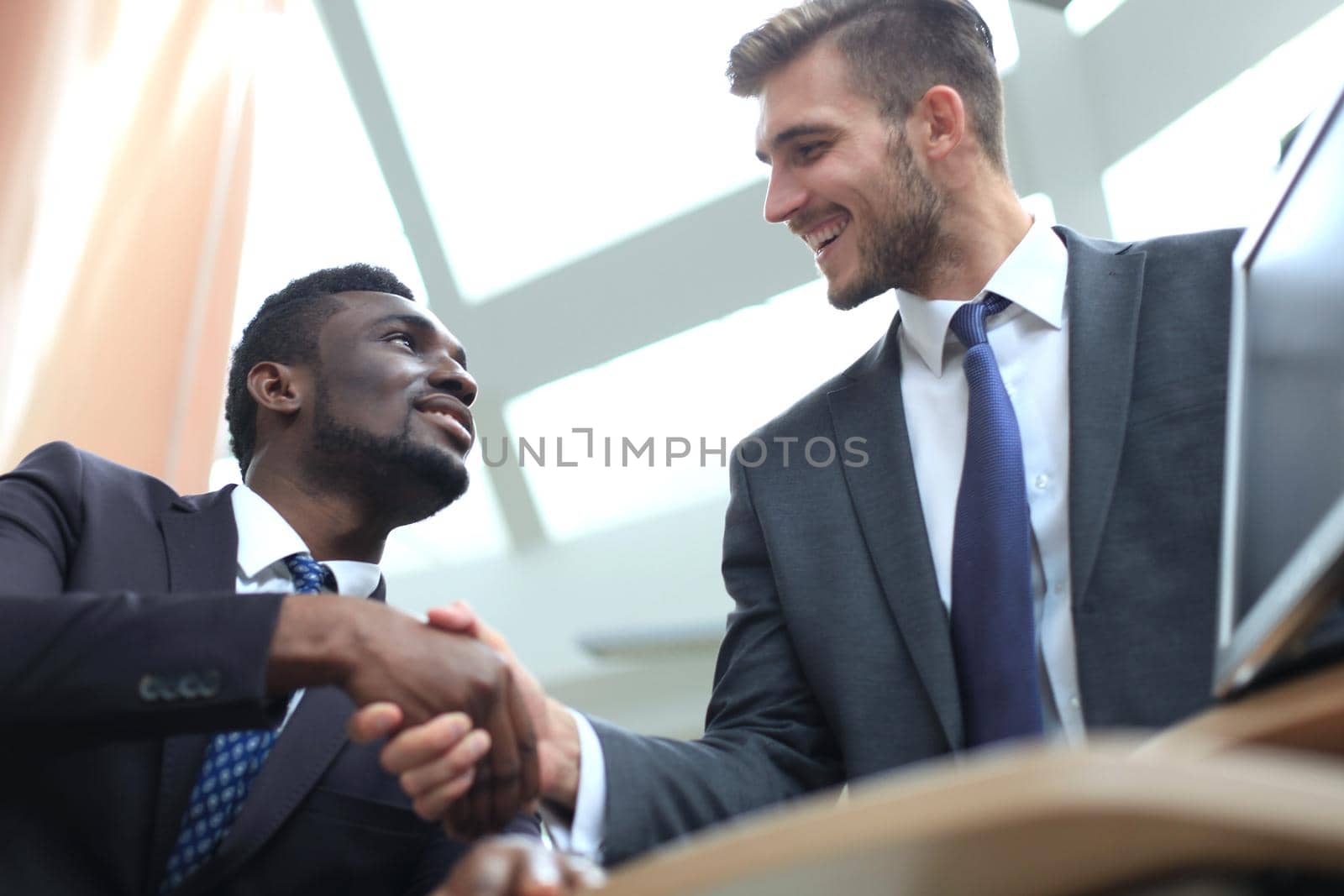 Business meeting. African American businessman shaking hands with caucasian businessman.