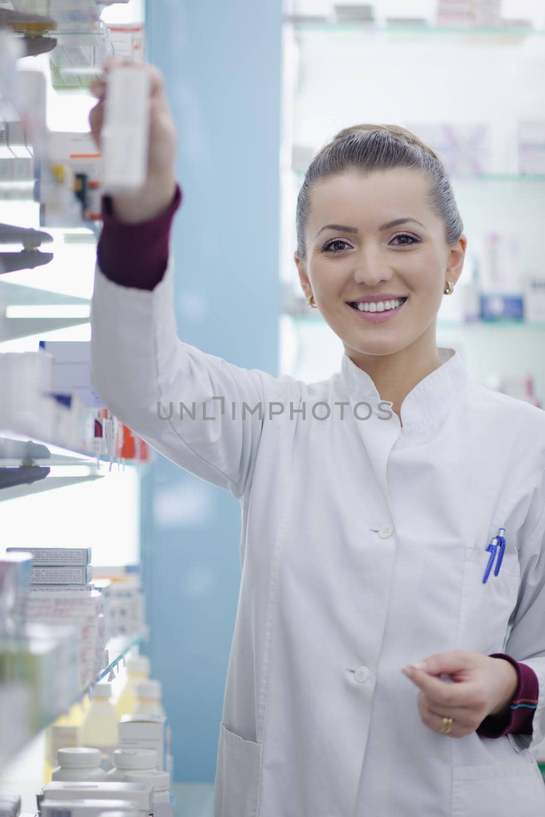 Happy cheerful pharmacist chemist woman standing in pharmacy drugstore