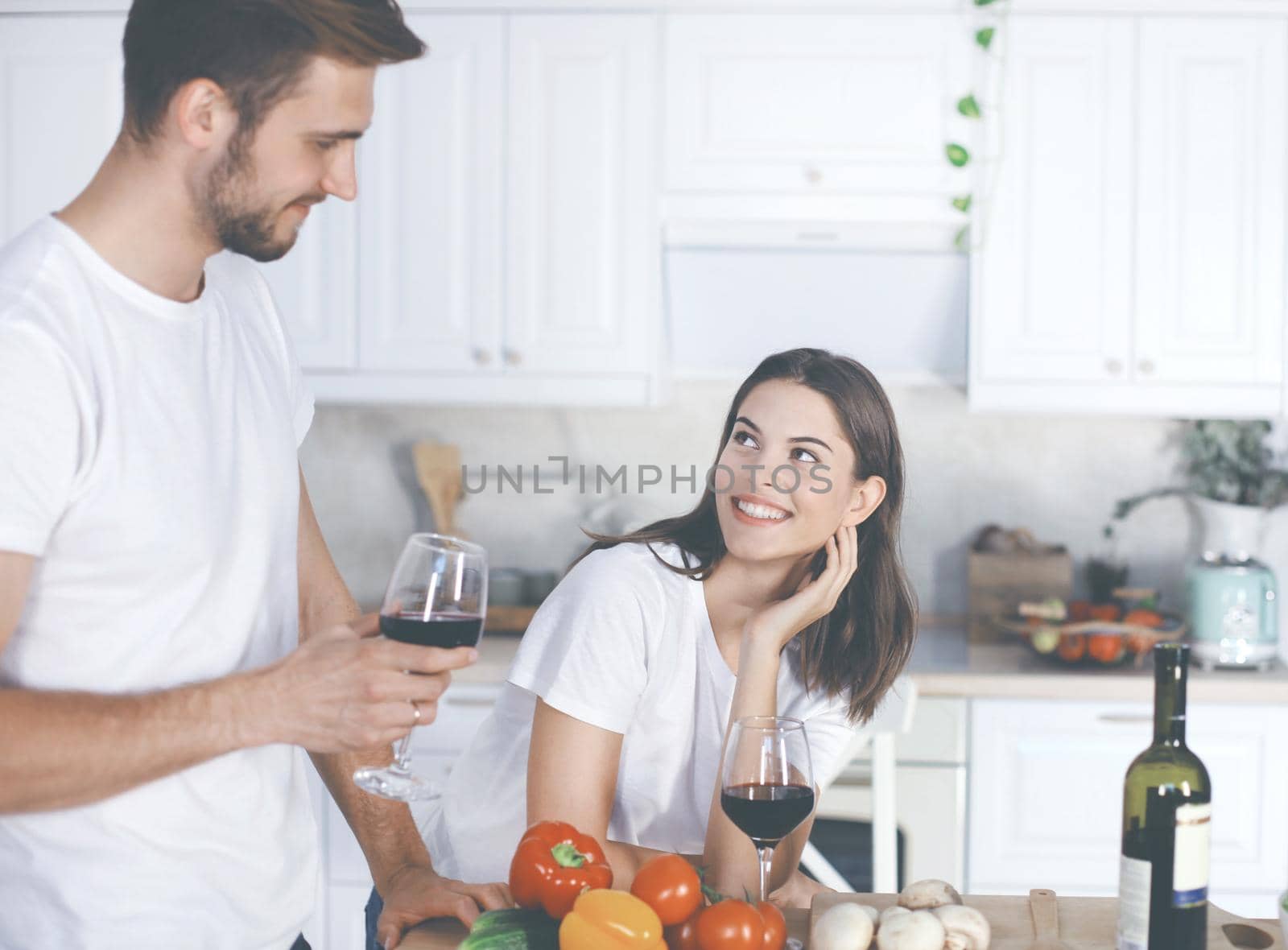 Beautiful young couple preparing a healthy meal together while spending free time at home. by tsyhun
