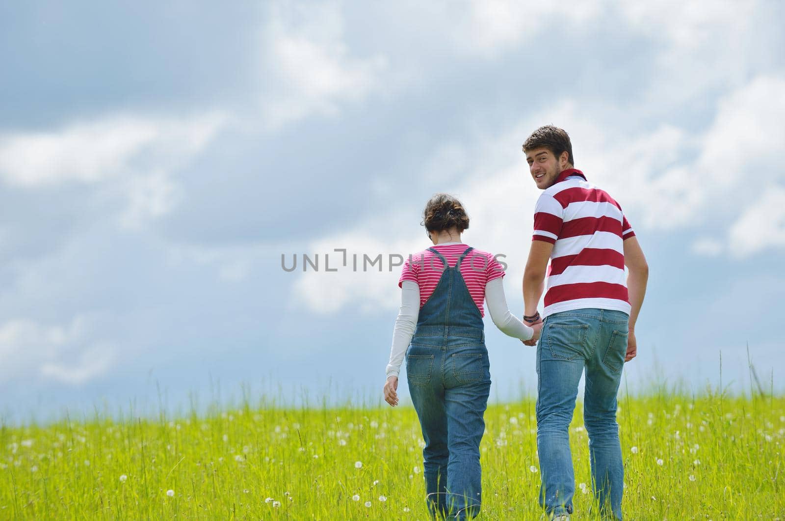 Portrait of romantic young couple in love  smiling together outdoor in nature with blue sky in background