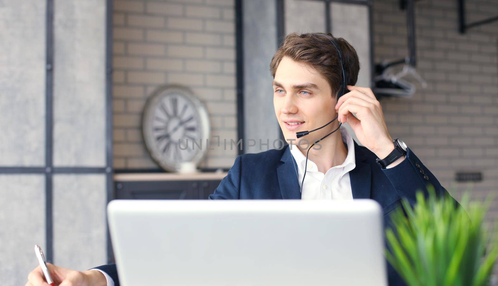 Smiling friendly handsome young male call centre operator.