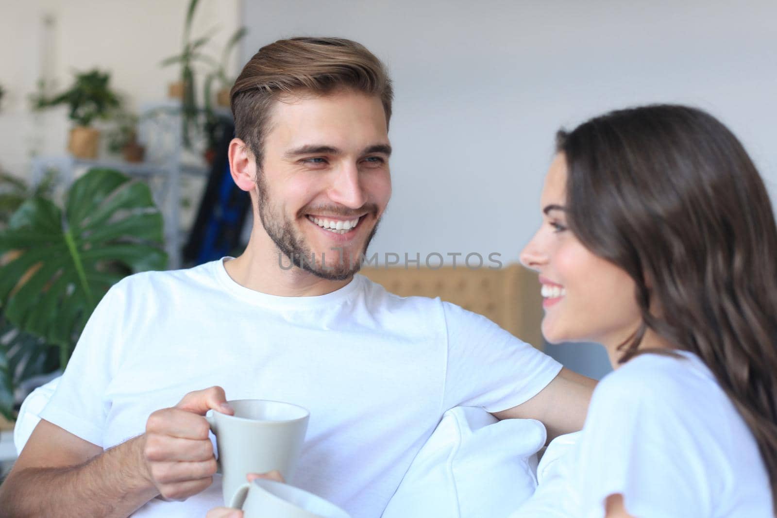 Cheerful young couple in the morning at home in the living room. by tsyhun