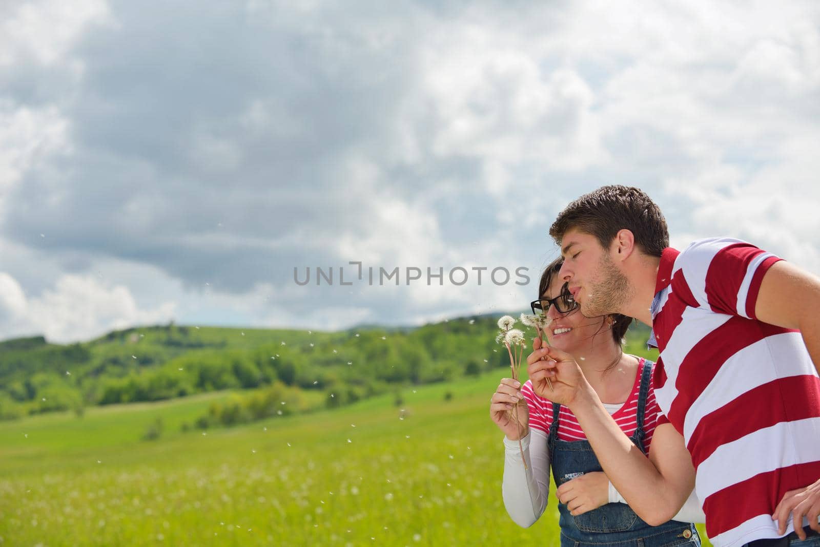 Portrait of romantic young couple in love  smiling together outdoor in nature with blue sky in background