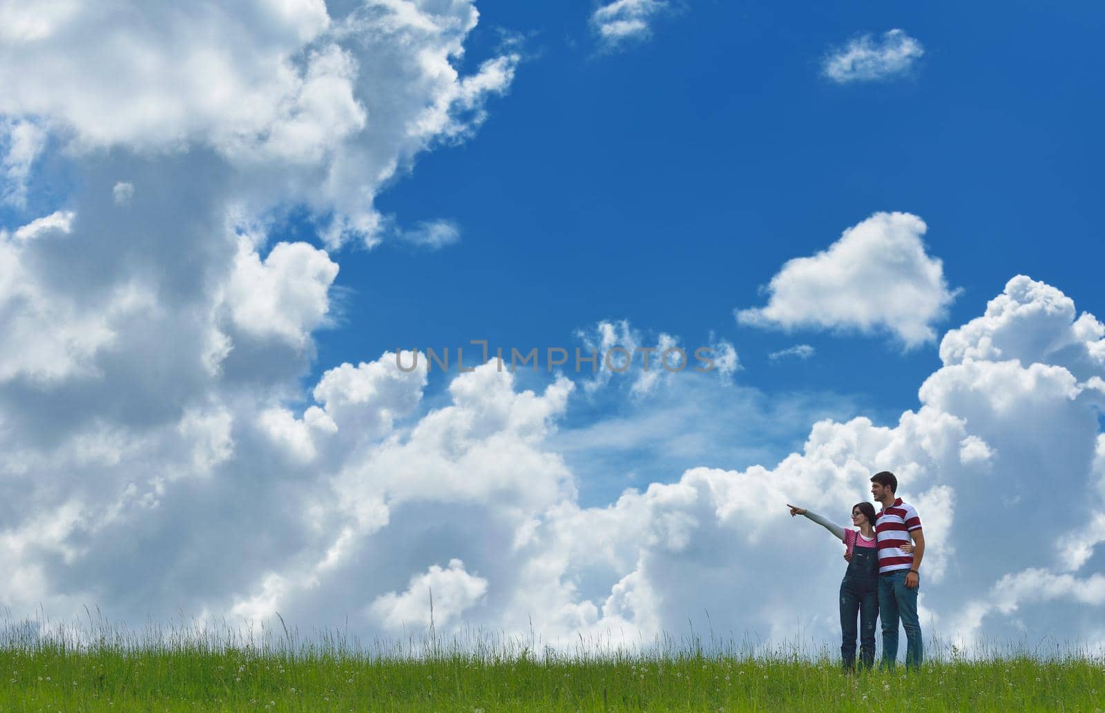 Portrait of romantic young couple in love  smiling together outdoor in nature with blue sky in background