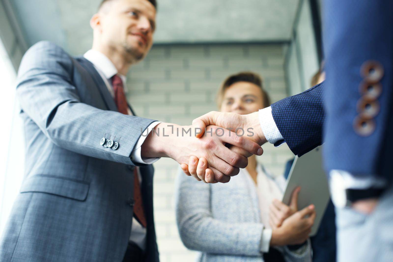 Business people shaking hands, finishing up a meeting. by tsyhun