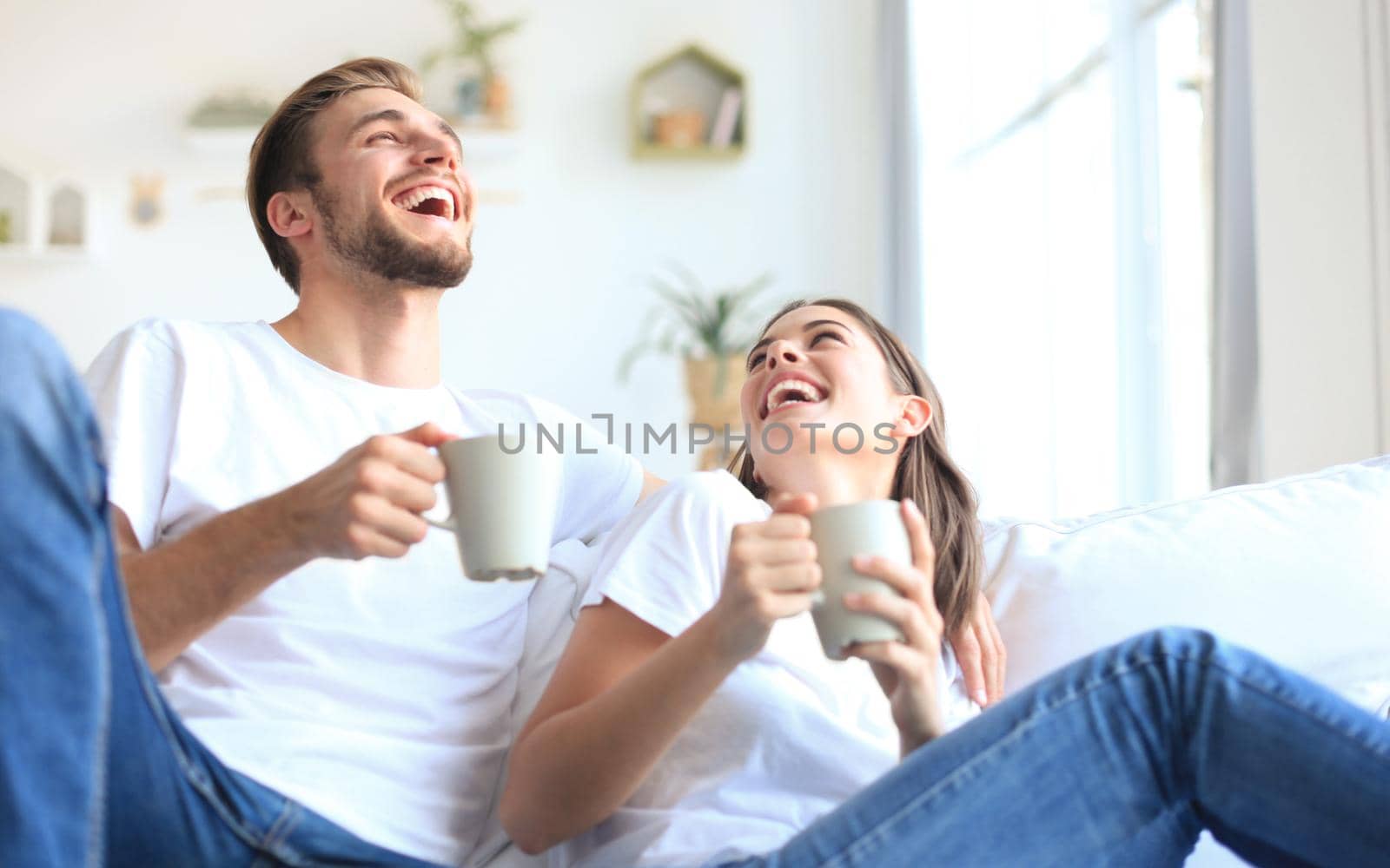 Cheerful young couple in the morning at home in the living room.