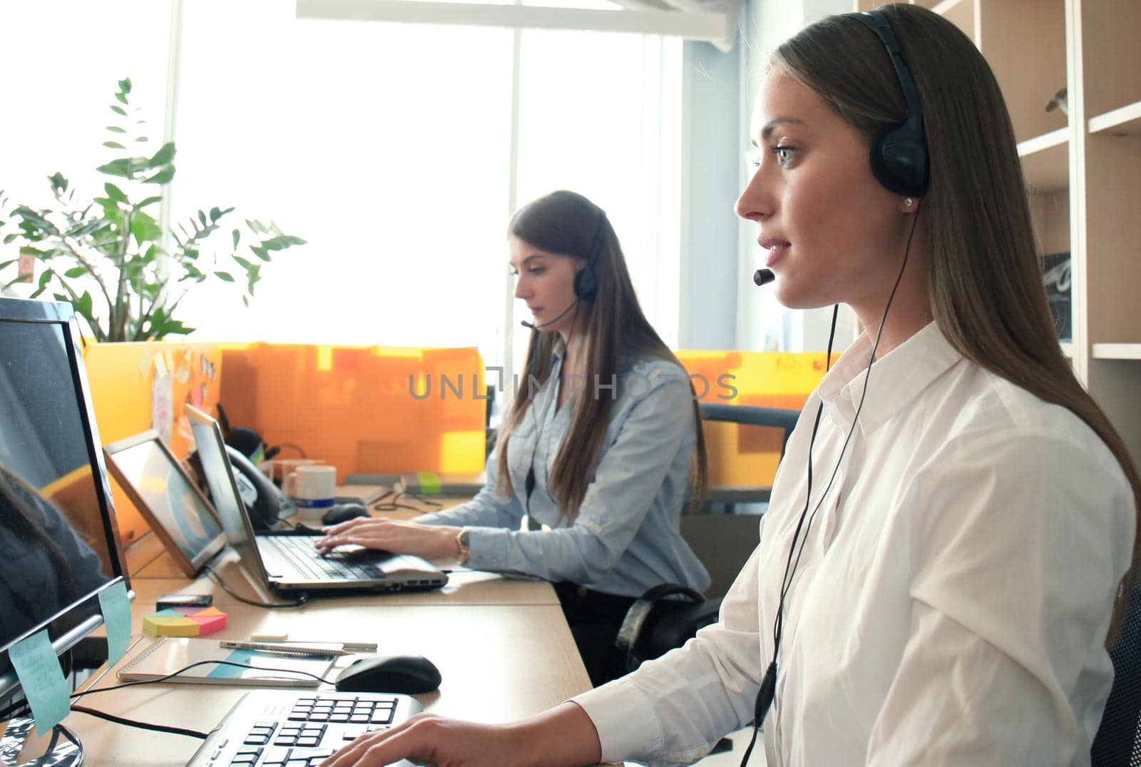 Attractive positive young businesspeople and colleagues in a call center office.