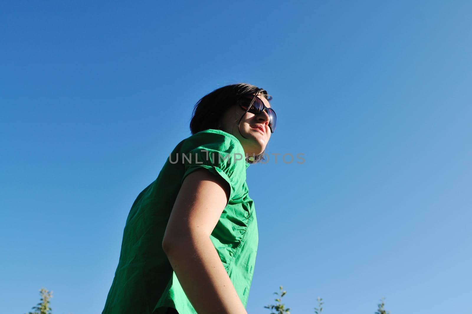 young beautiful brunette woman jump outdoor in fashion clothing and sunglasses