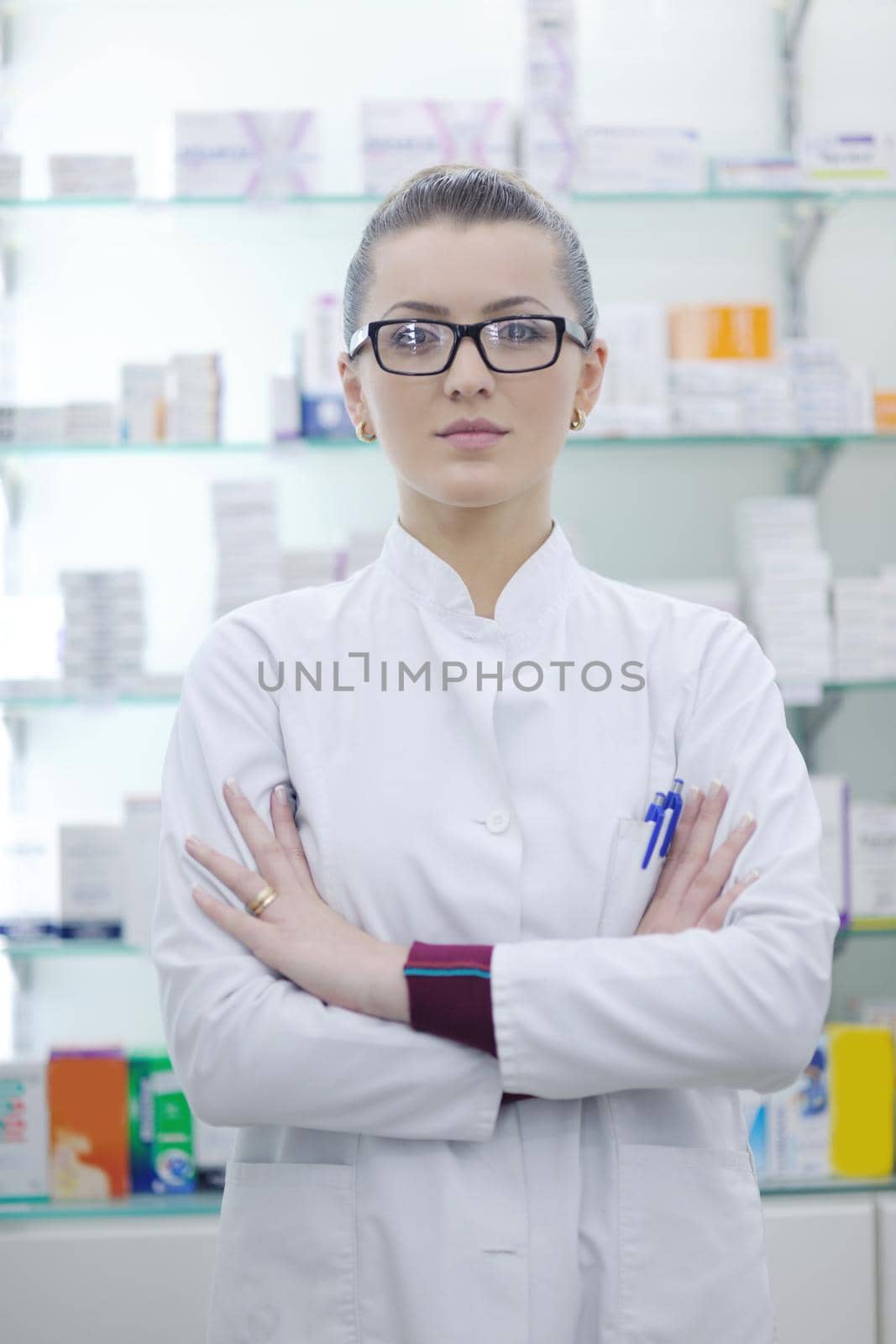 pharmacist chemist woman standing in pharmacy drugstore by dotshock
