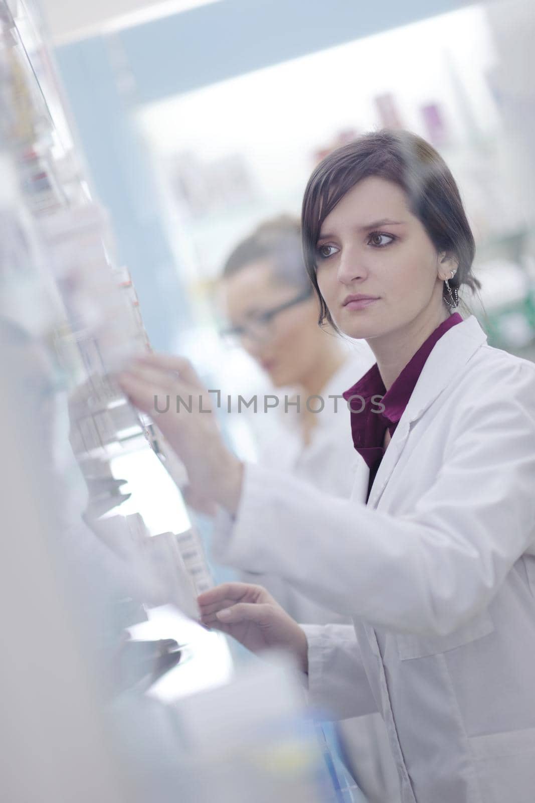 pharmacist chemist woman standing in pharmacy drugstore by dotshock
