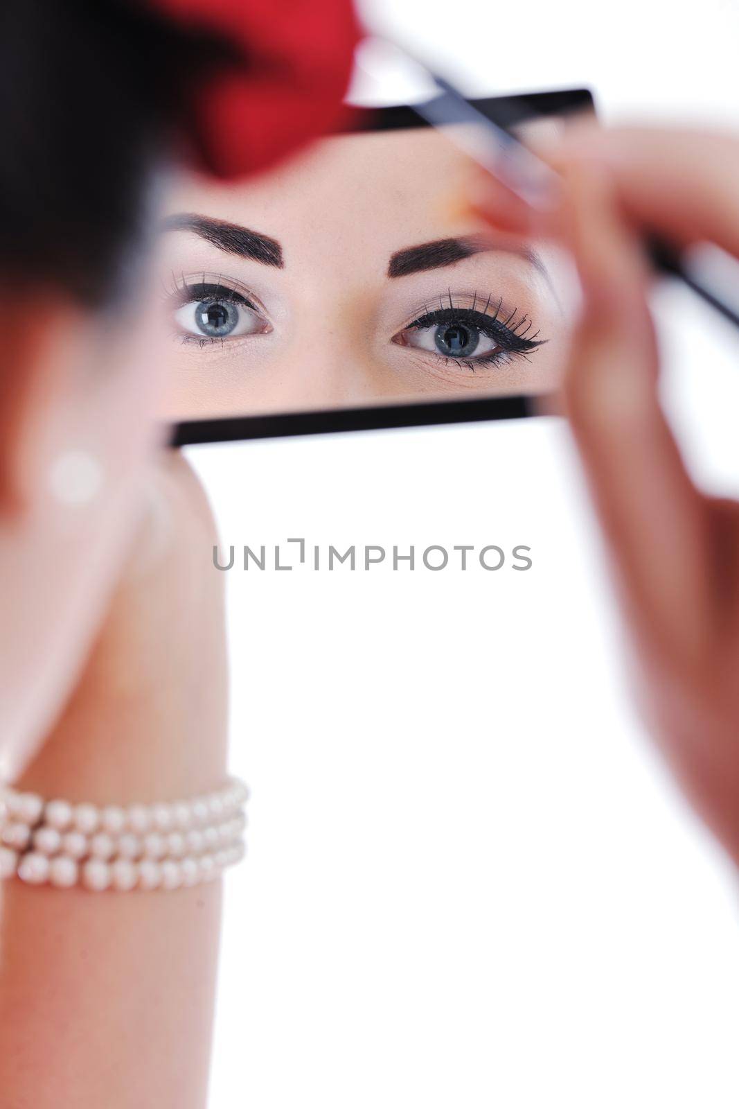 beautiful young woman applying makeup by dotshock