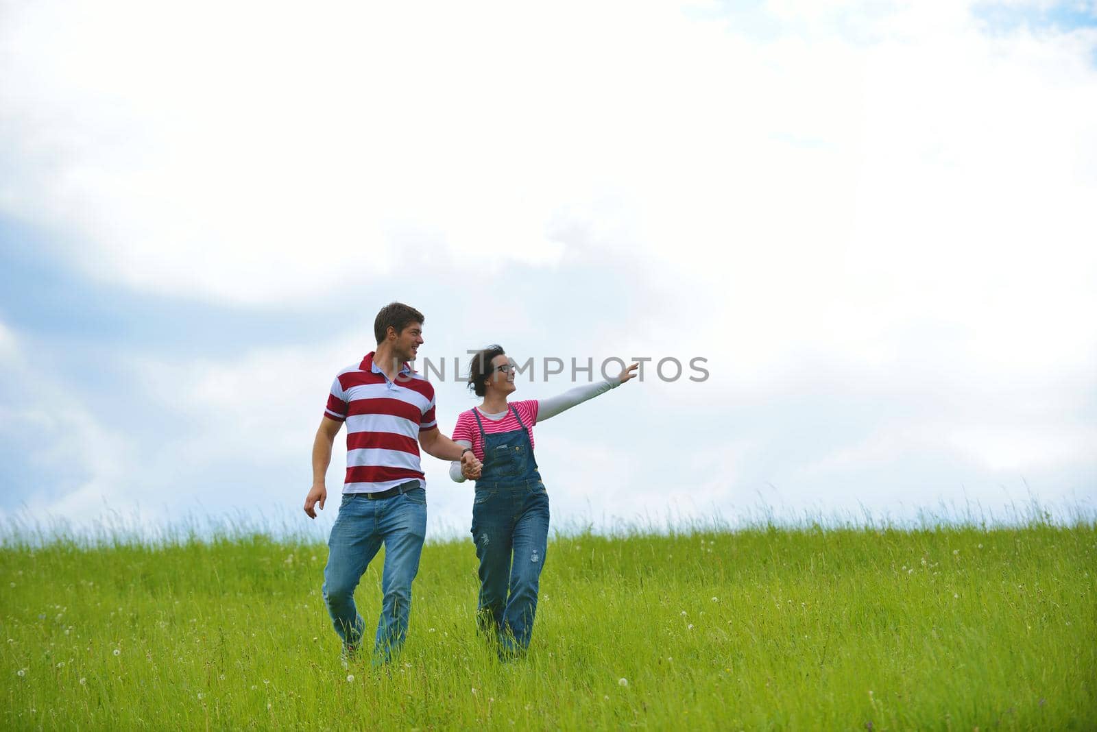 Portrait of romantic young couple in love  smiling together outdoor in nature with blue sky in background