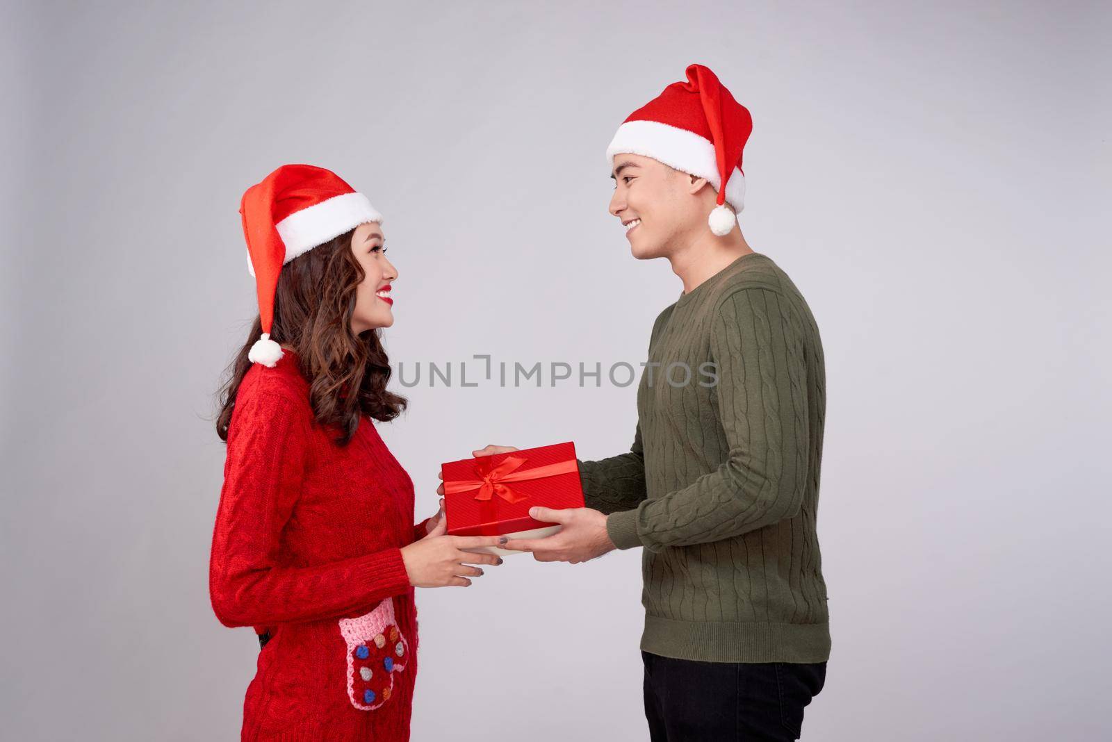 Handsome young man giving present to beautiful woman. Christmas time.