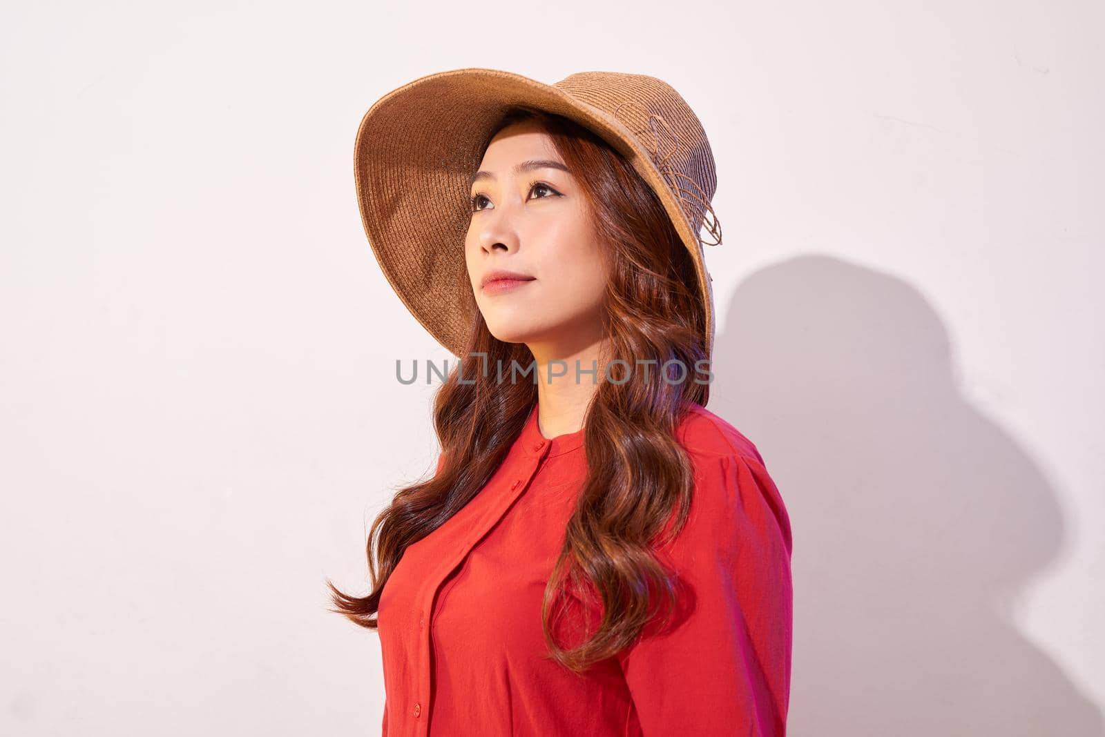 Beautiful young lady in straw hat over white background