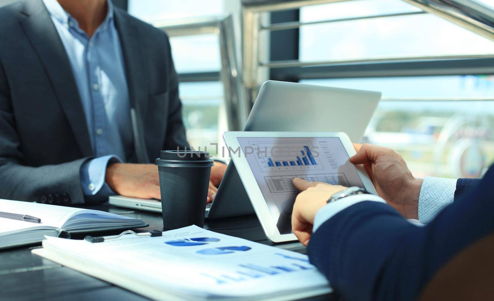 Business person analyzing financial statistics displayed on the tablet screen by tsyhun