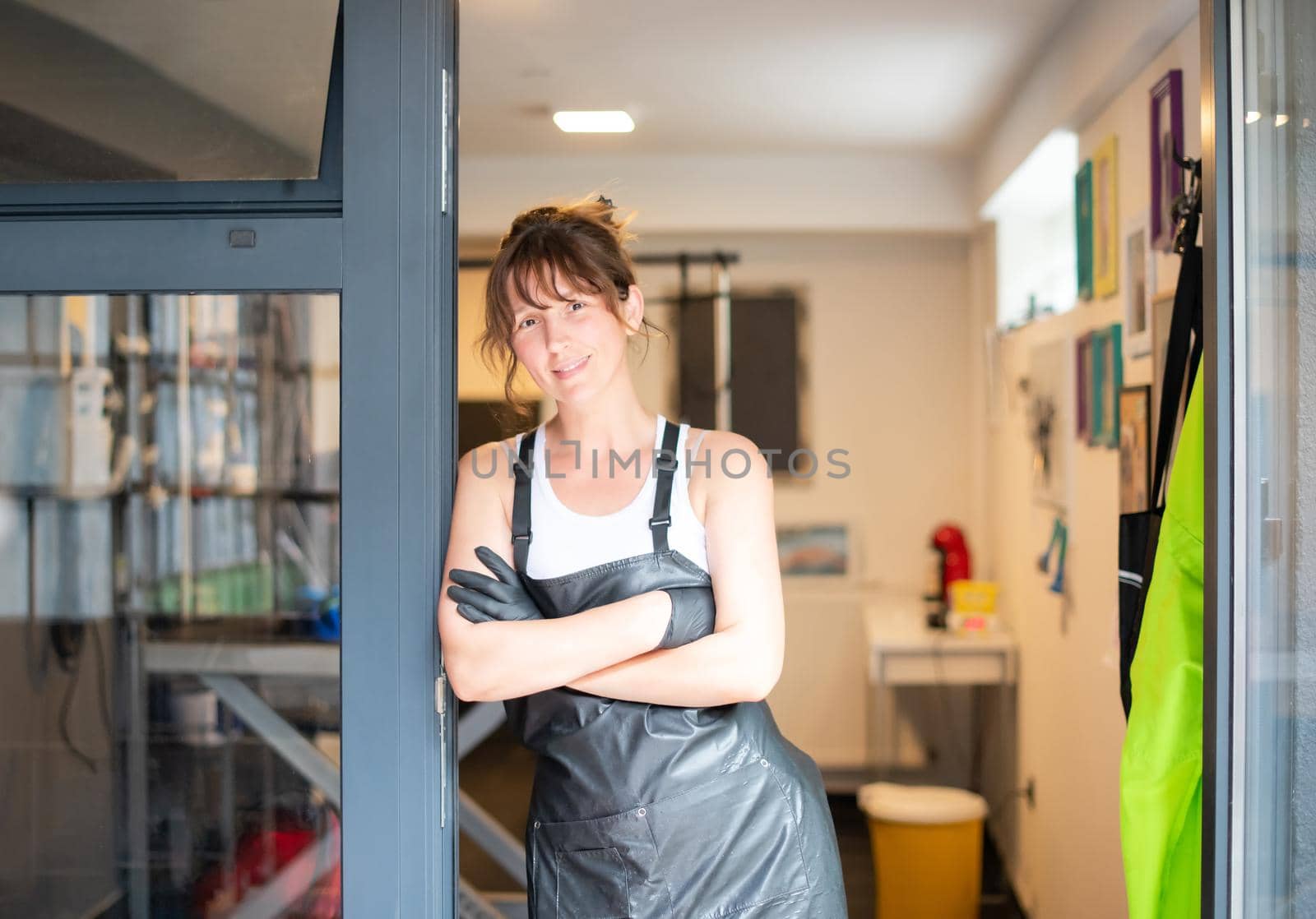 portrait of professional pet hairdresser hipster woman while standing at the door of her beauty salon for animals