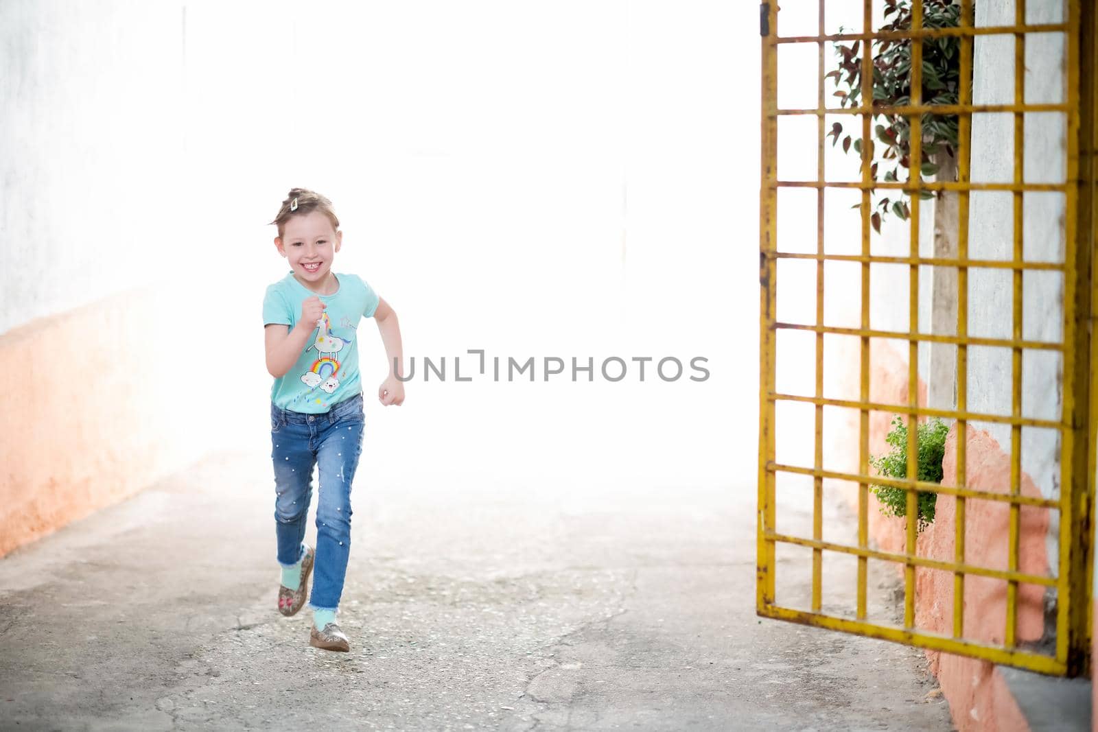 happy cute little girl enjoying running through the streets of the city