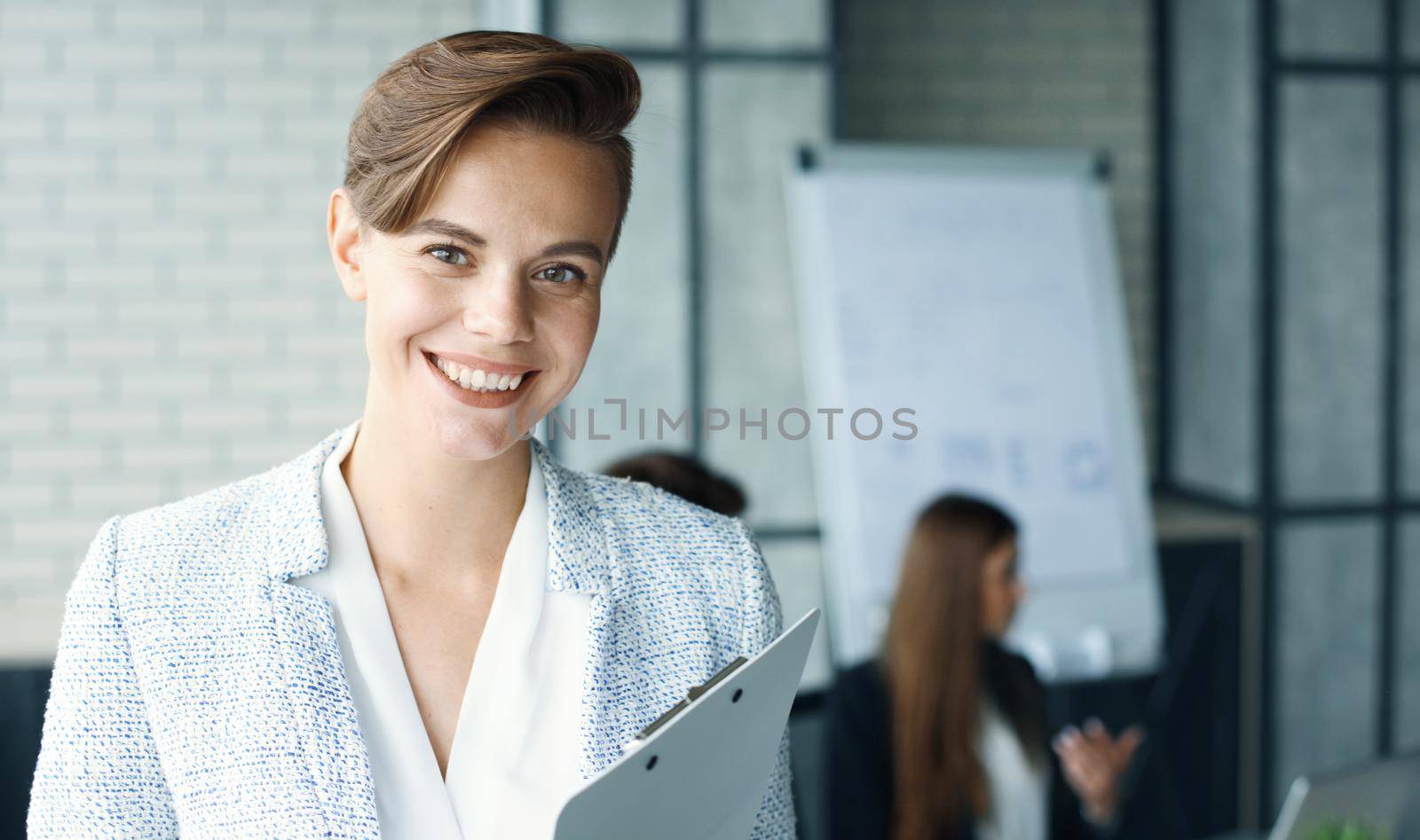 business woman with her staff, people group in background at modern bright office indoors