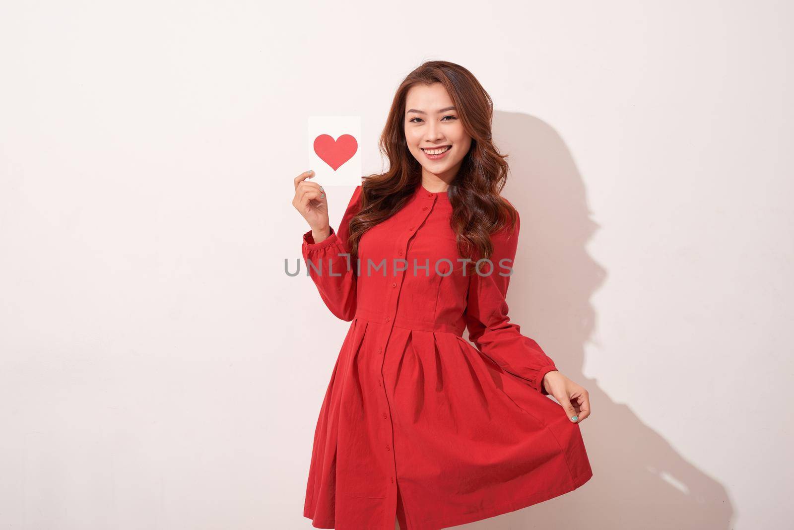 Lovely female with red heart isolated on gray background, celebration of Valentine day, romantic feelings, harmony and love concept