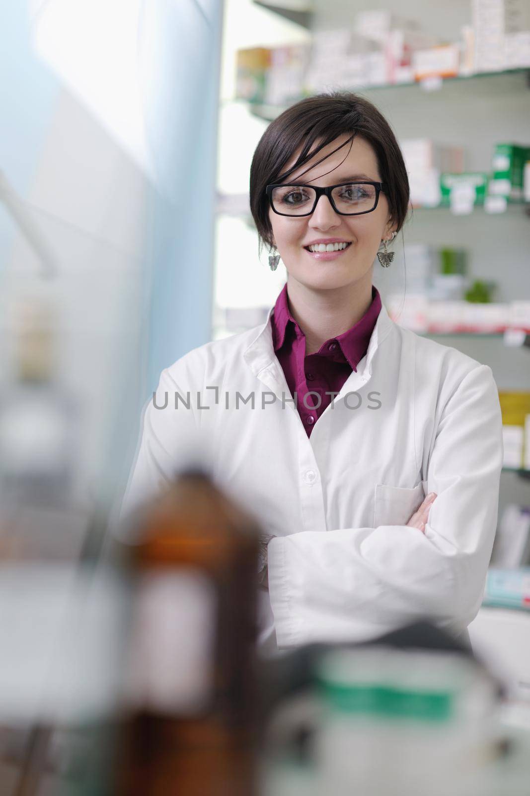 Happy cheerful pharmacist chemist woman standing in pharmacy drugstore