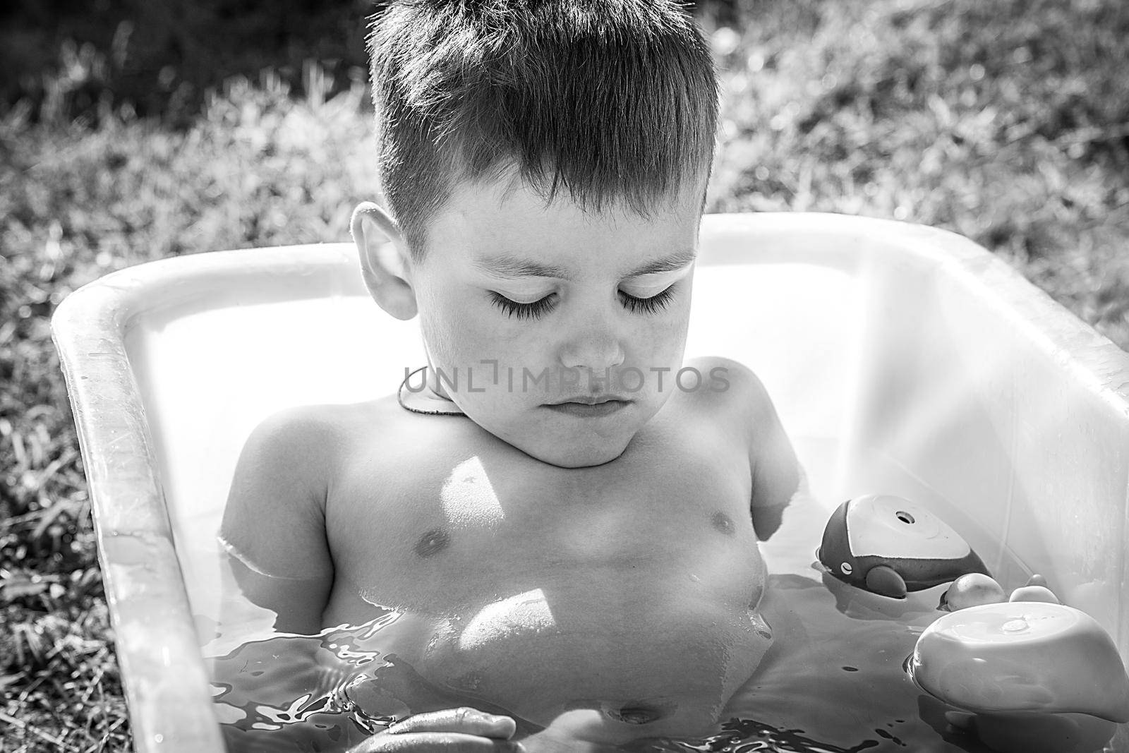 Black and white photo little boy sleeping in a bath black and white photo
