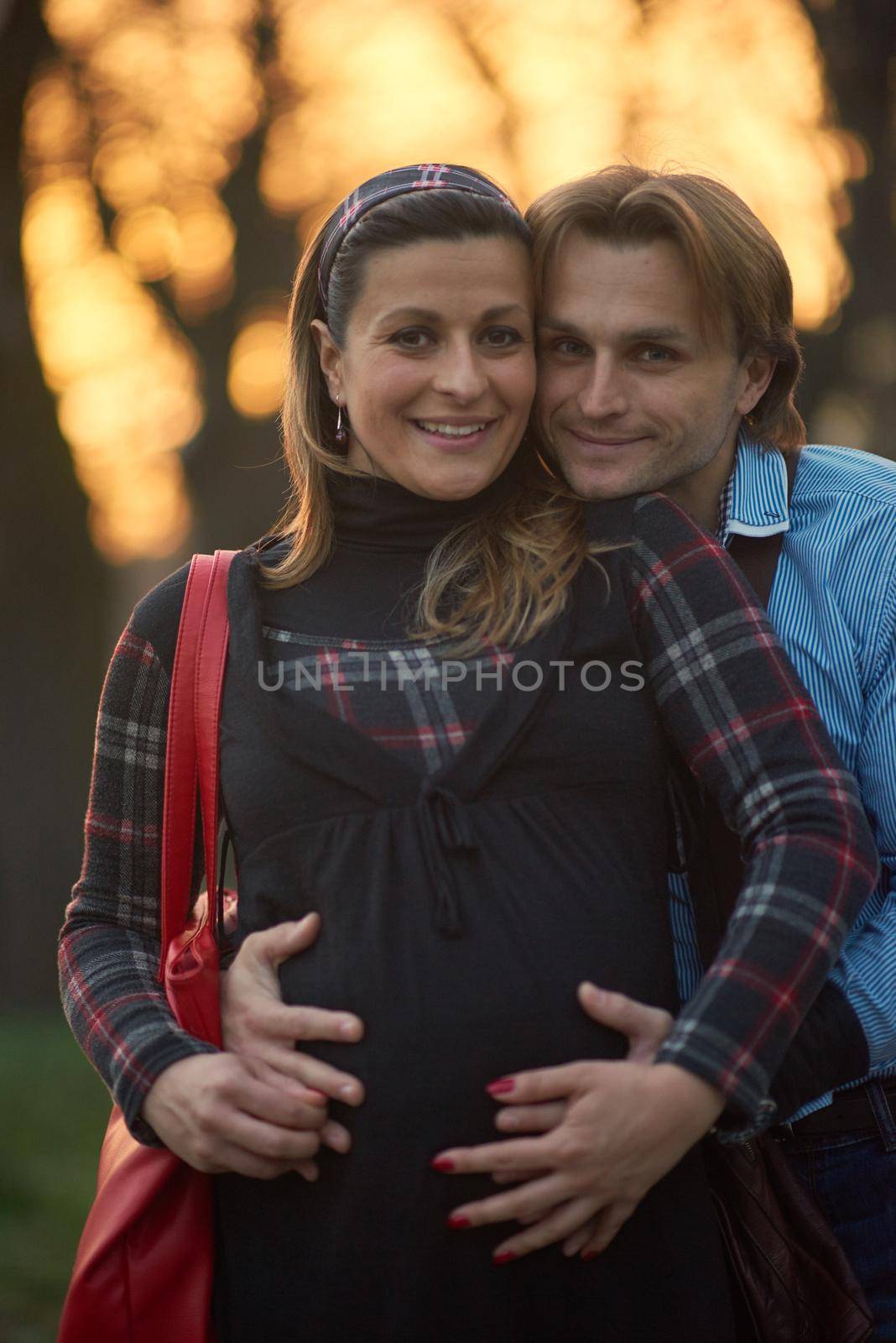 young pregnant couple have fun and relax by dotshock