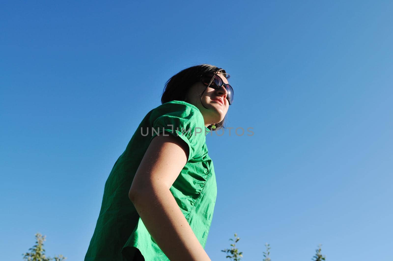 young beautiful brunette woman jump outdoor in fashion clothing and sunglasses