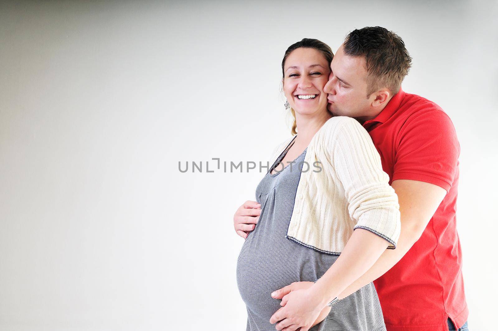 young family couple together in studio isolated on white. happy and waiting for baby