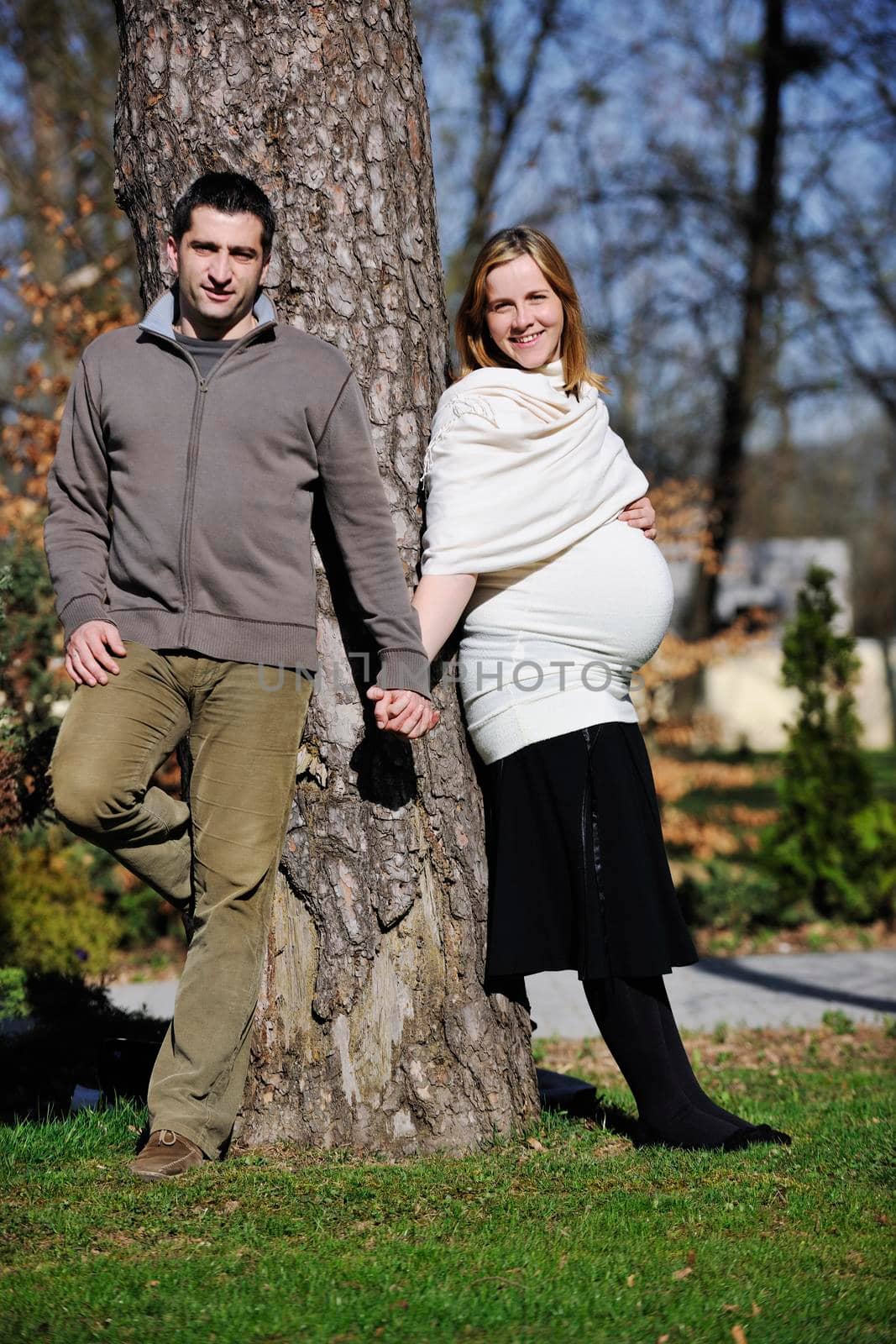 happy young married family couple outdoor in nature have fun and waiting baby and representing young family growth and pregnancy concept