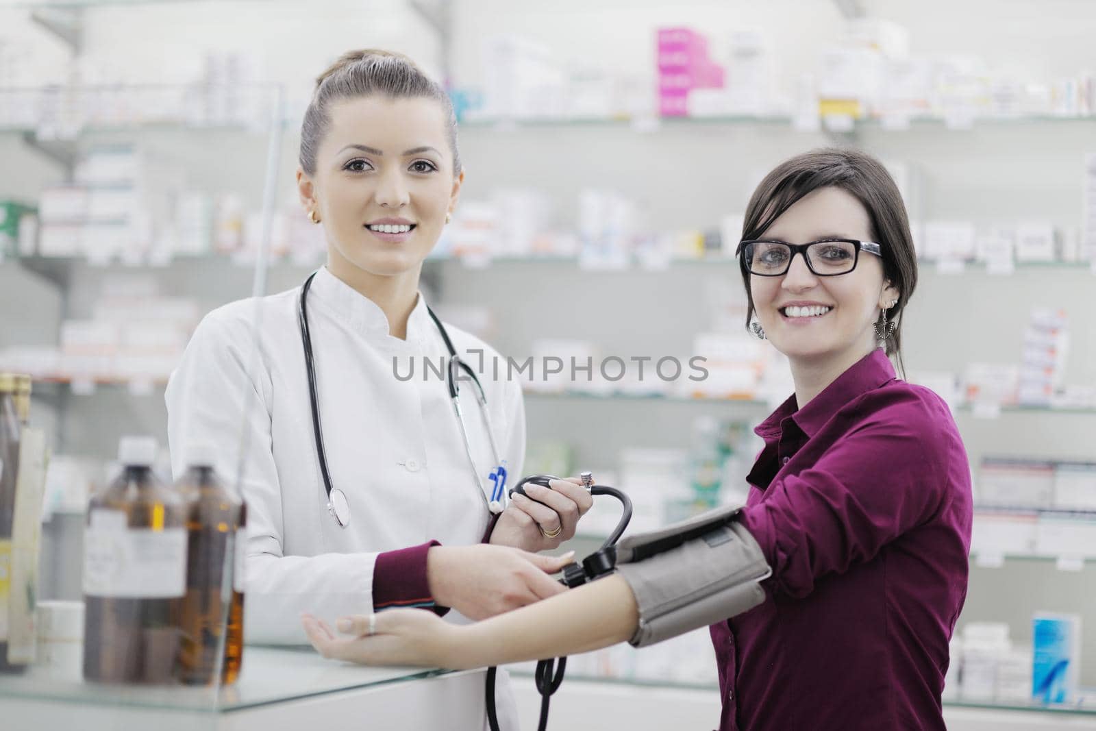 doctor checking blood pressure and heart rate in a hospital or in pharmacy with young female patient