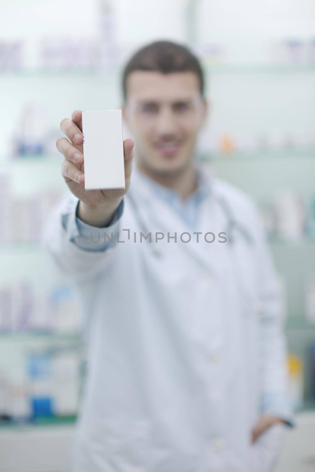 portrait of handsome young  pharmacist chemist man standing in pharmacy drugstore