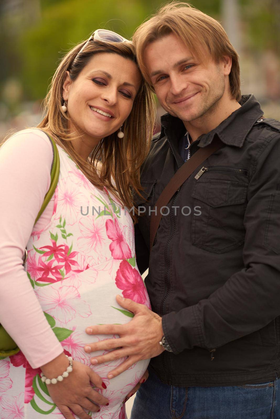 Happy and young pregnant couple have fun and relax outdoor