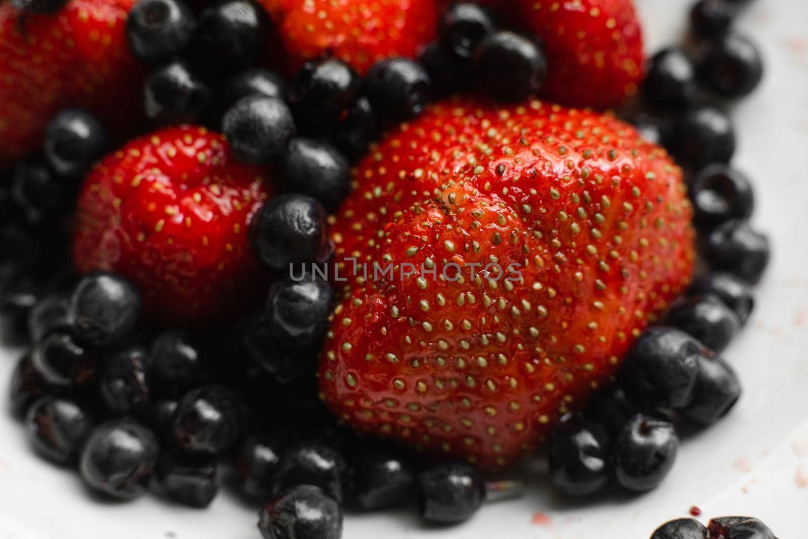 Many juicy fresh ripe red strawberry berries with blackberries isolated on white background by StudioLucky