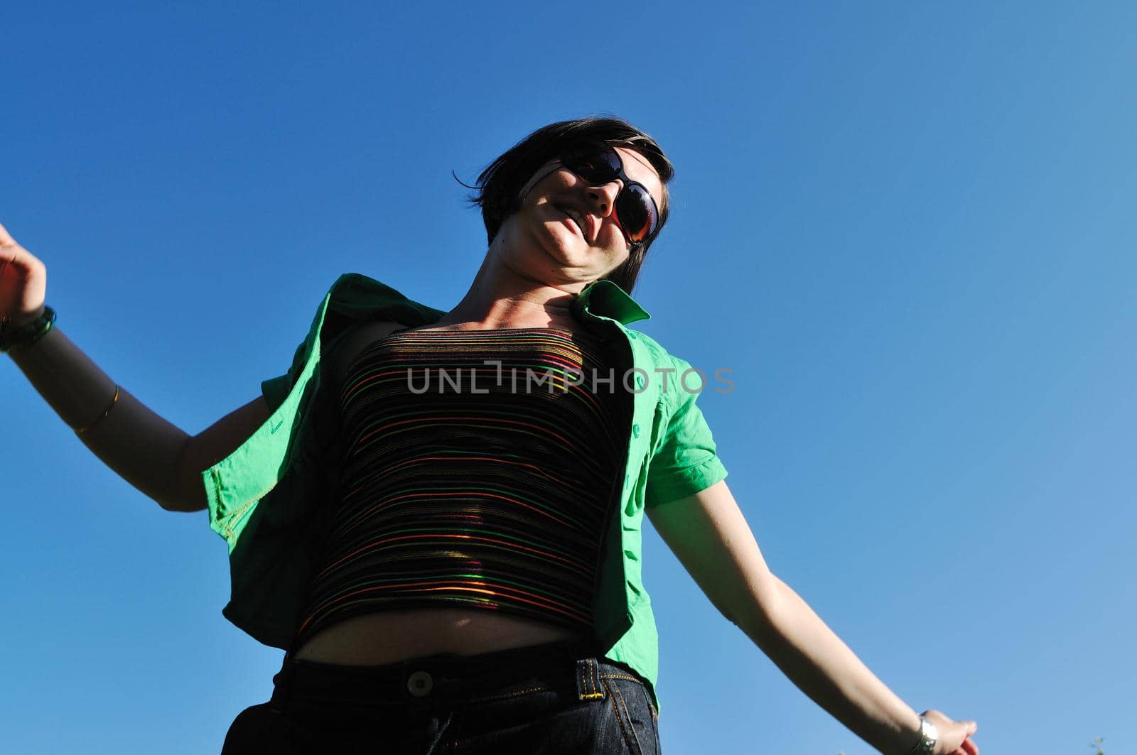 young beautiful brunette woman jump outdoor in fashion clothing and sunglasses