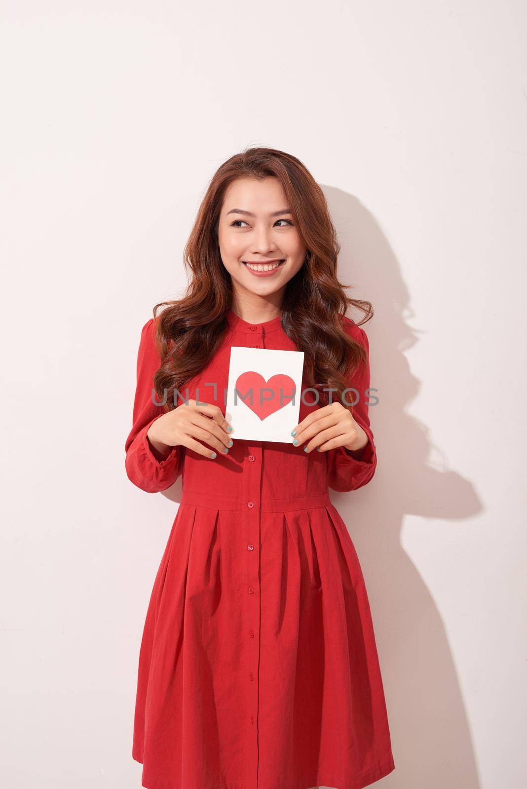 Portrait of happy romantic girl with red paper heart-shaped postcard. by makidotvn
