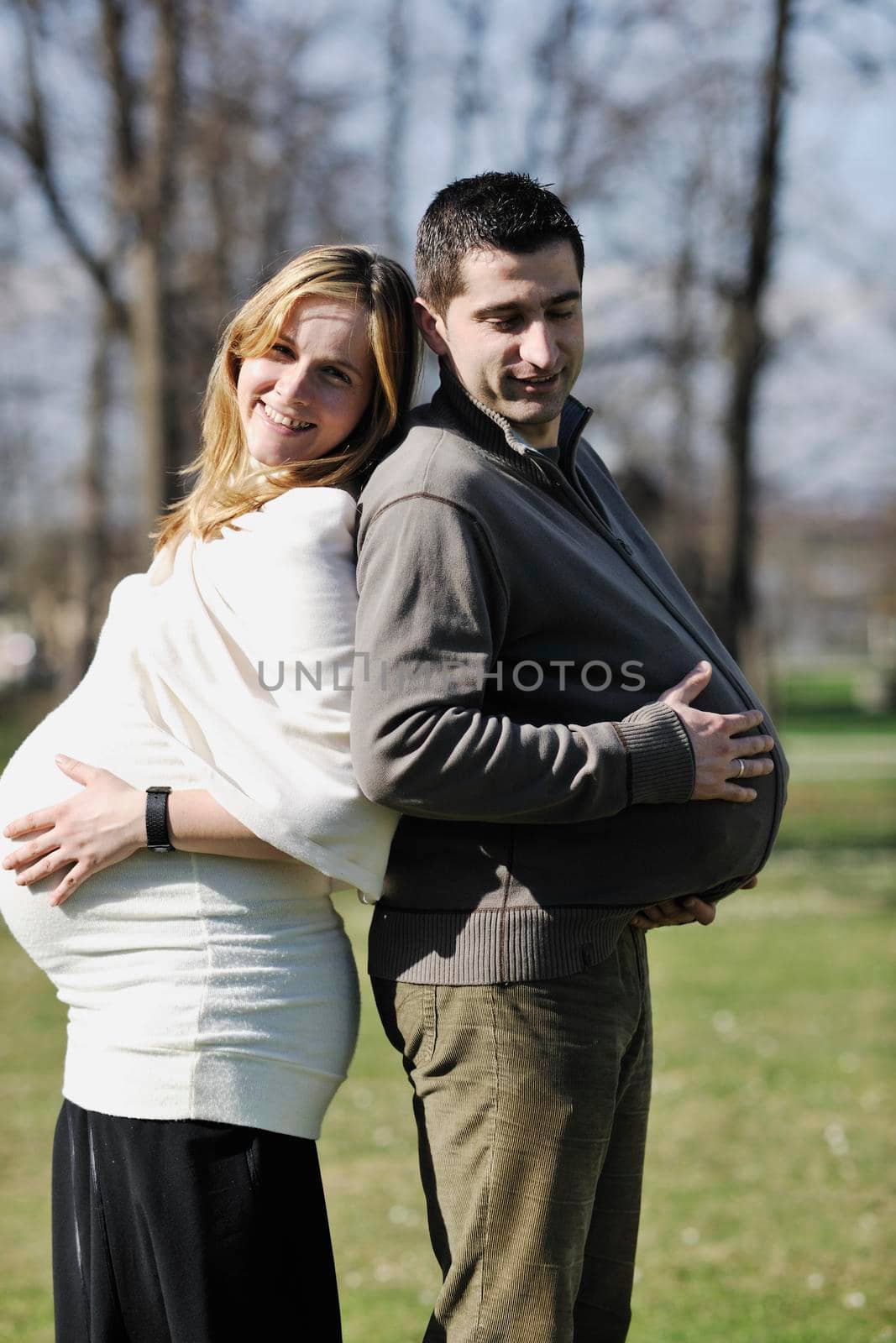 happy young married family couple outdoor in nature have fun and waiting baby and representing young family growth and pregnancy concept