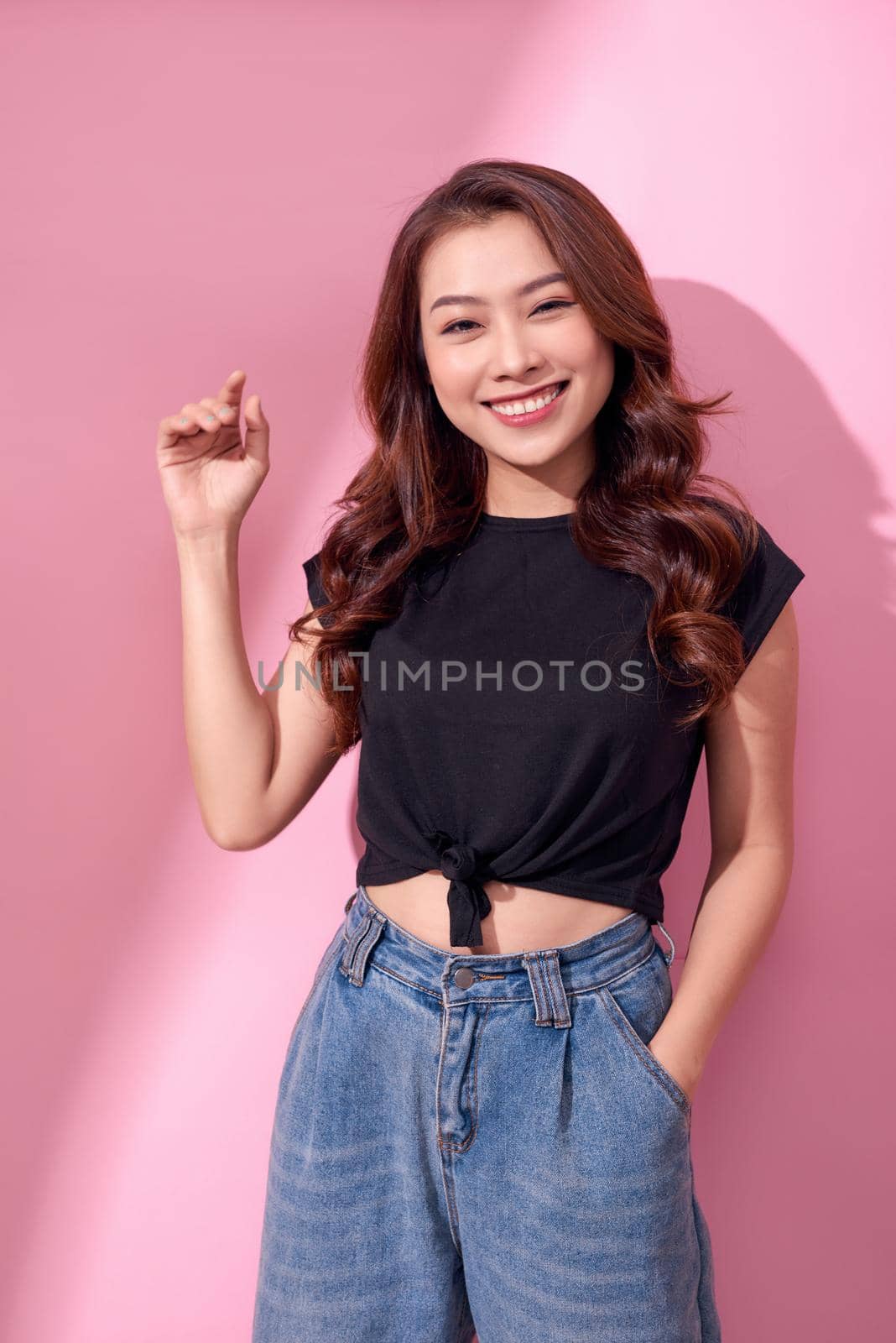 lifestyle, beauty and people concept: Young cute smiling girl over pink background